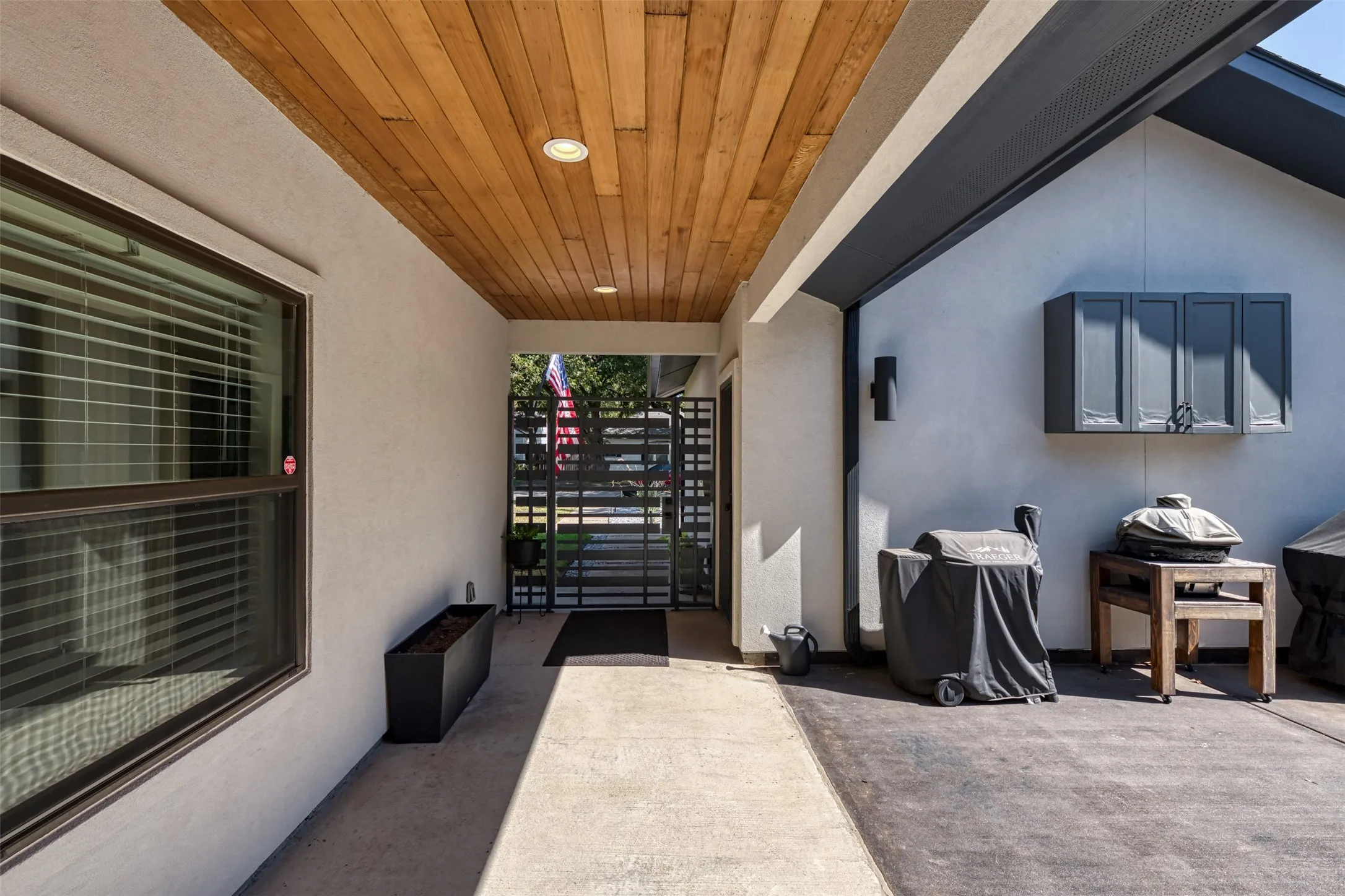 Covered entryway with wood-finish ceiling paneling and recessed lighting