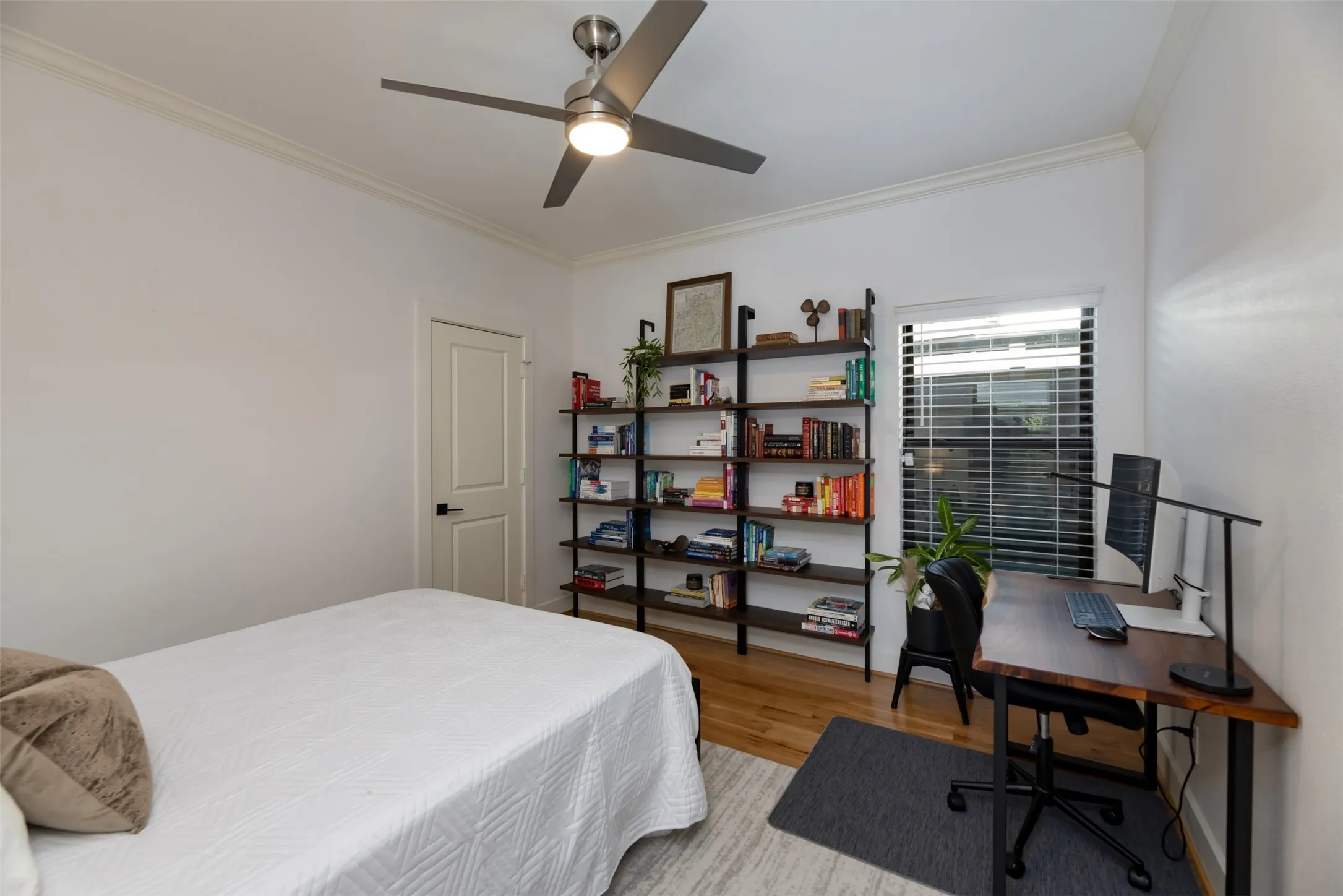 Crown molding, wood-finish flooring, and a modern ceiling fan with lighting