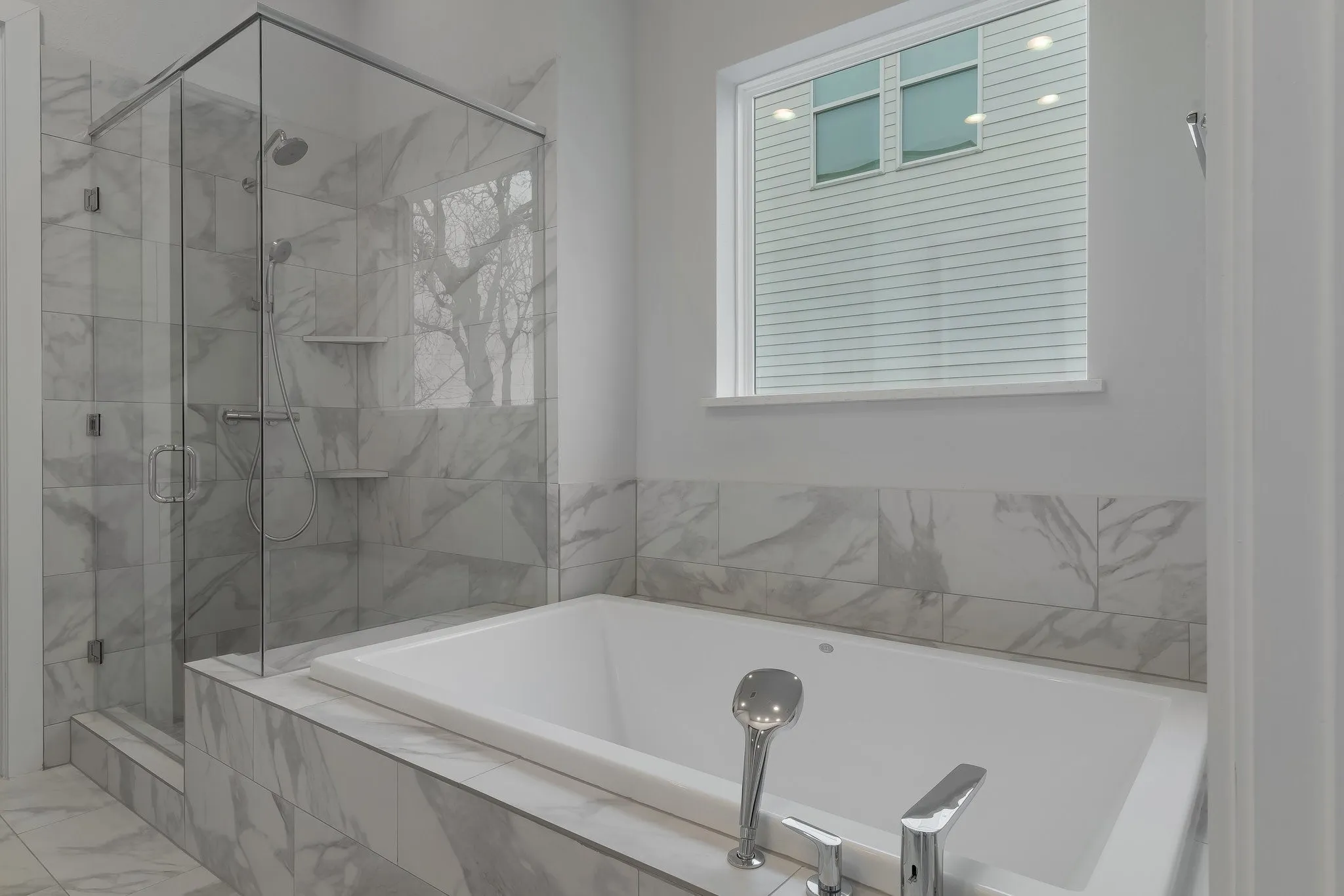 Full bathroom with a garden tub, marble finish floor, and a shower stall