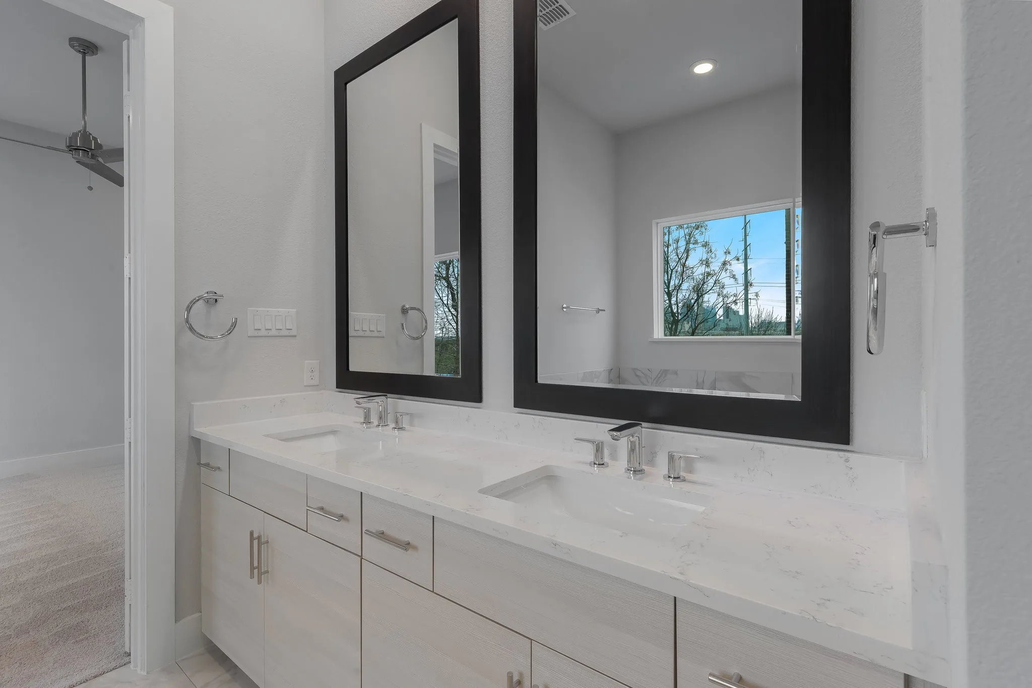Bathroom featuring baseboards, visible vents, a sink, and double vanity
