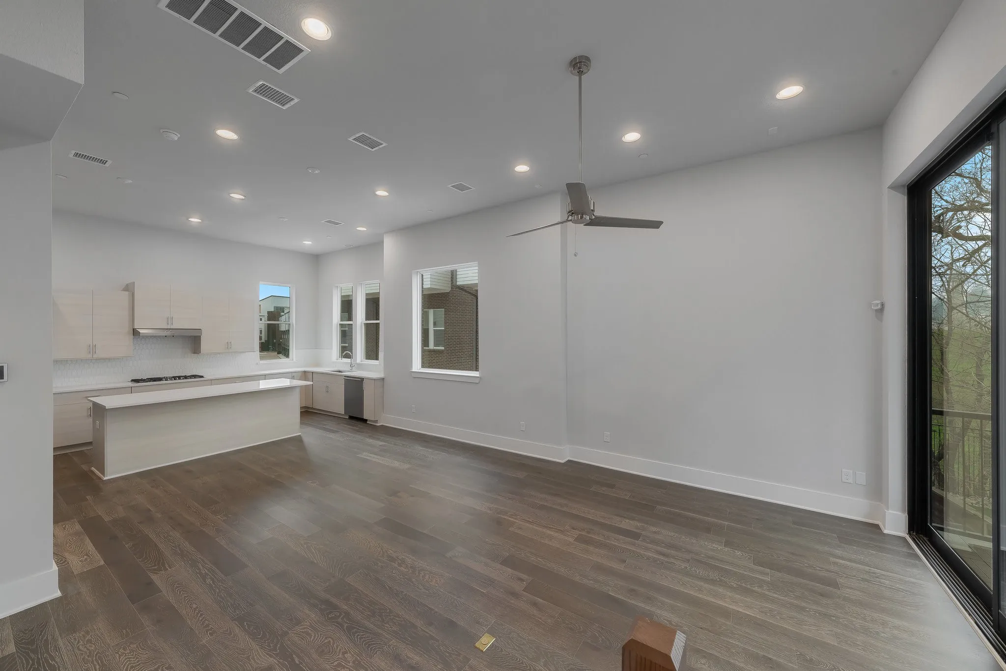 Unfurnished living room with a ceiling fan, visible vents, recessed lighting, and dark wood-type flooring
