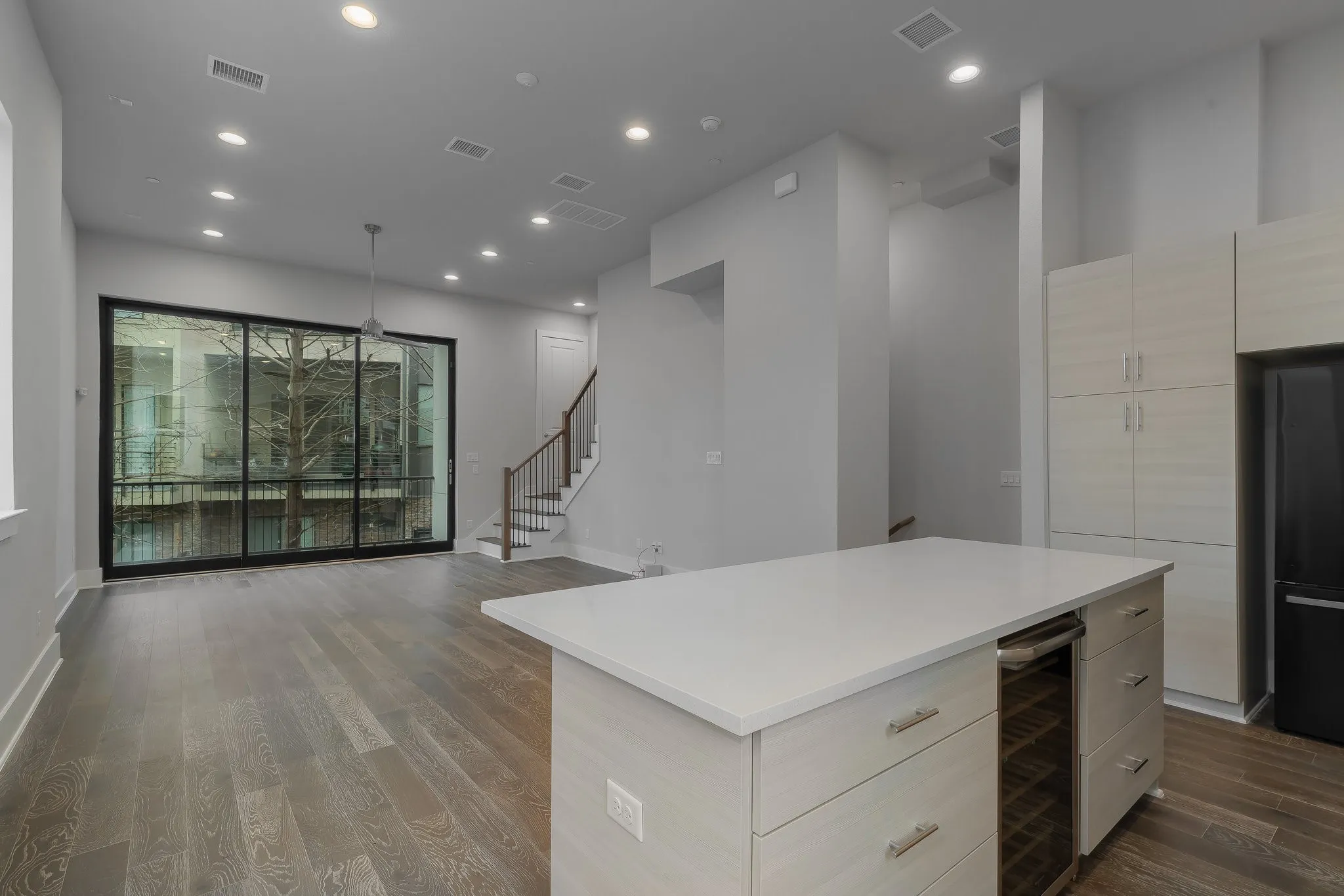 Kitchen featuring modern cabinets, visible vents, wine cooler, and light countertops