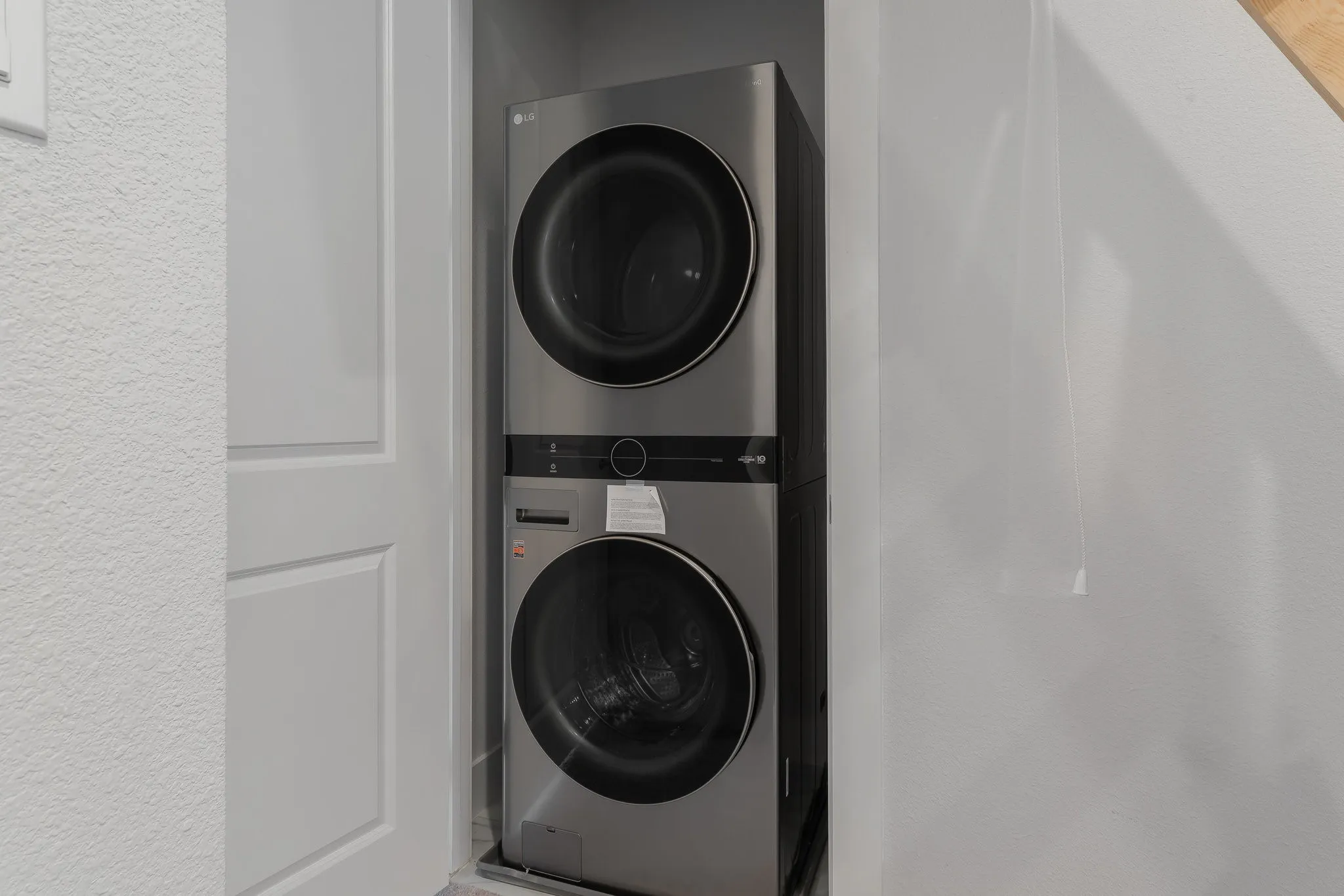 Washroom featuring stacked washer and dryer and laundry area