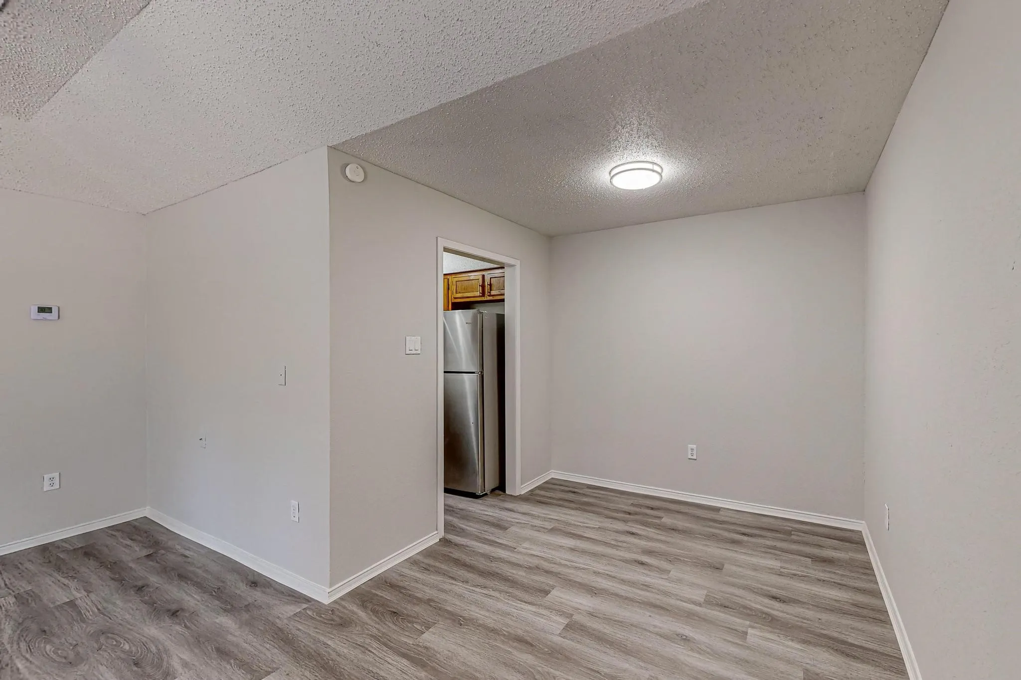 Wood-finish flooring, neutral wall tones, and overhead lighting