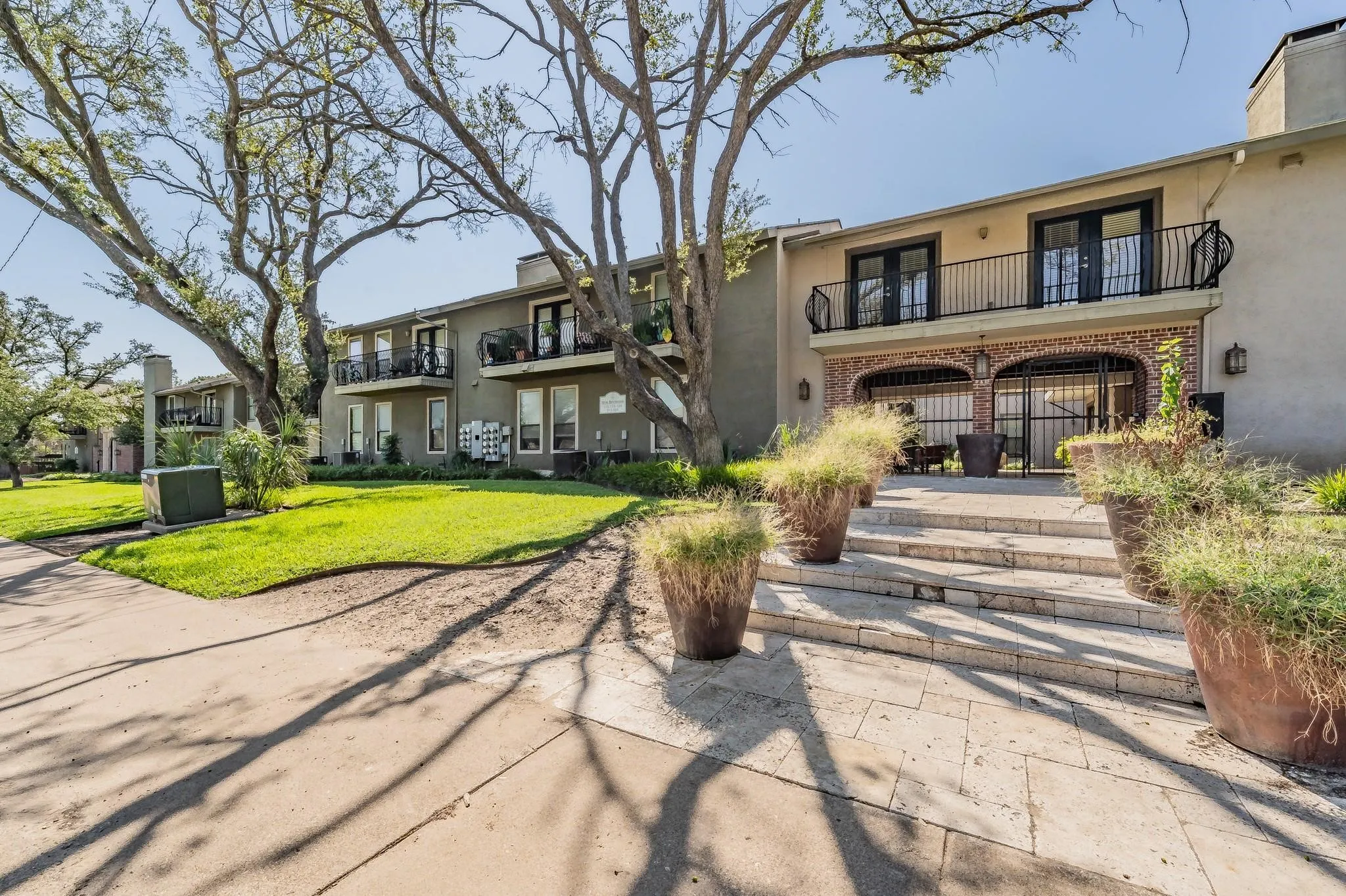 Exterior with stucco finish and multiple balconies featuring black wrought iron railings