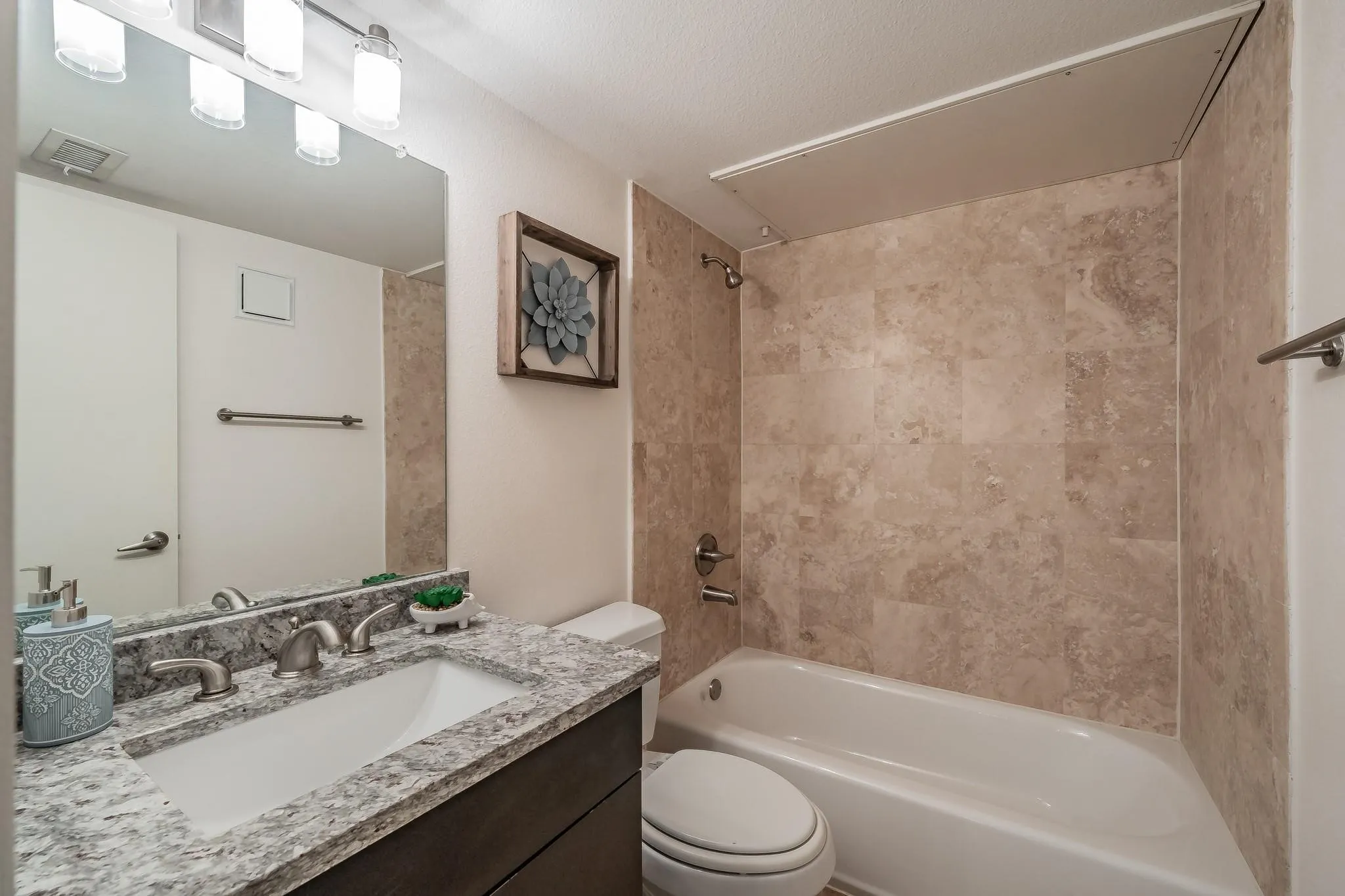Vanity with granite-style countertop, undermount sink, and brushed nickel faucet