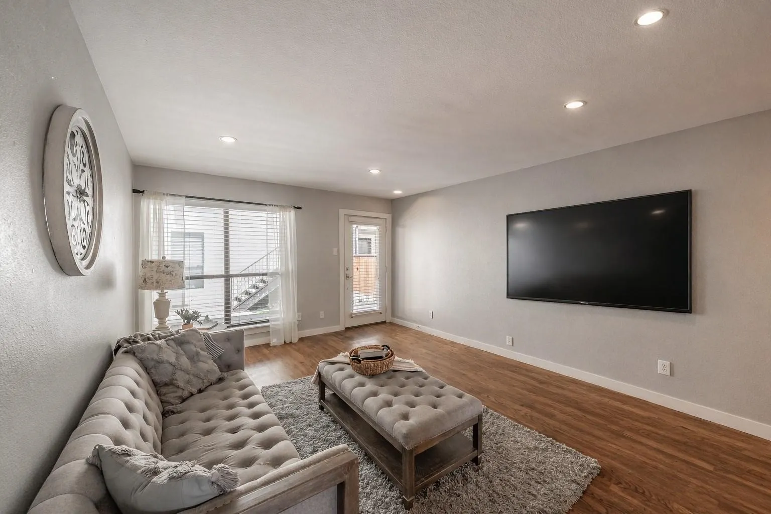 Recessed ceiling lighting illuminates the interior, featuring wood-finish flooring and light gray painted walls