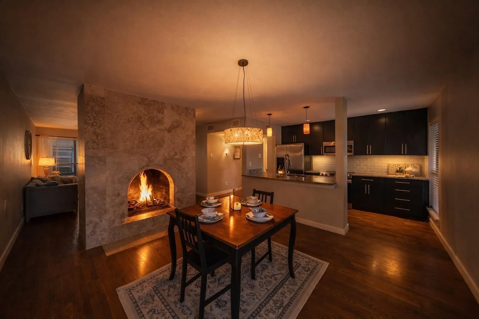 Wood-finish flooring throughout, featuring a stone-clad fireplace with an arched opening