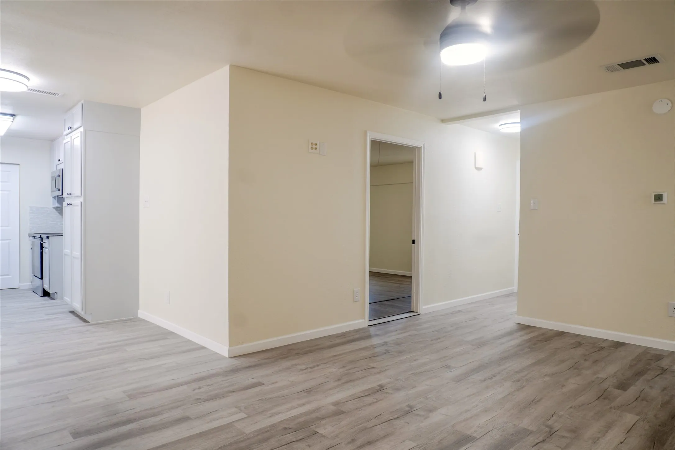 Wood-finish flooring throughout, complemented by light-toned walls and recessed lighting