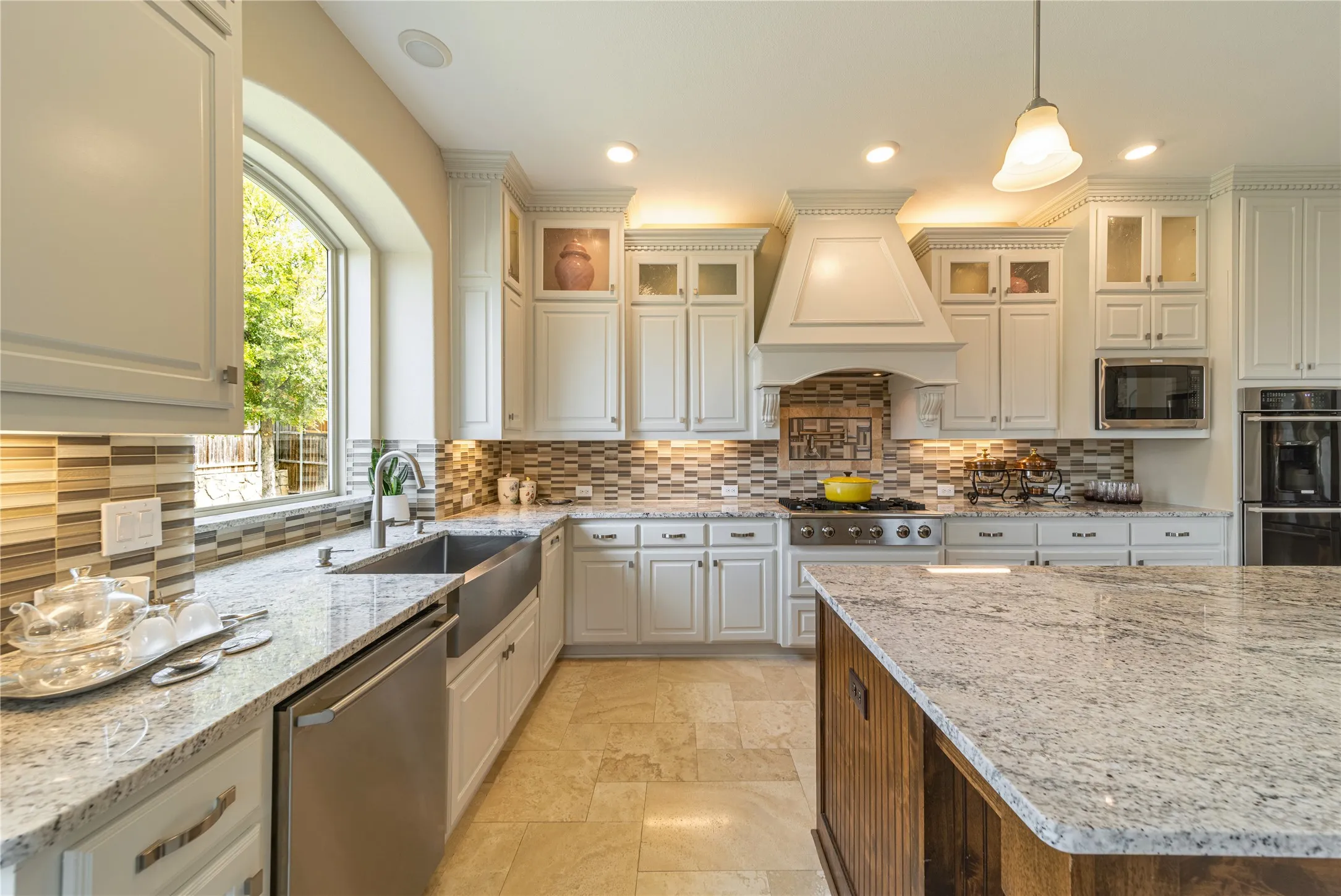 Spacious kitchen featuring white cabinetry,
Travertine floor, Electrolux appliances, a large center​​‌​​​​‌​​‌‌​‌‌​​​‌‌​‌​‌​‌​​​‌​​ island