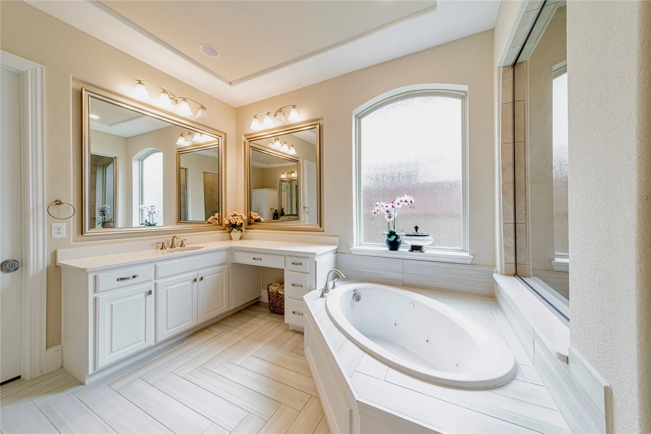Dual vanity with white cabinetry and integrated makeup counter, complemented by framed mirrors with sconce lighting