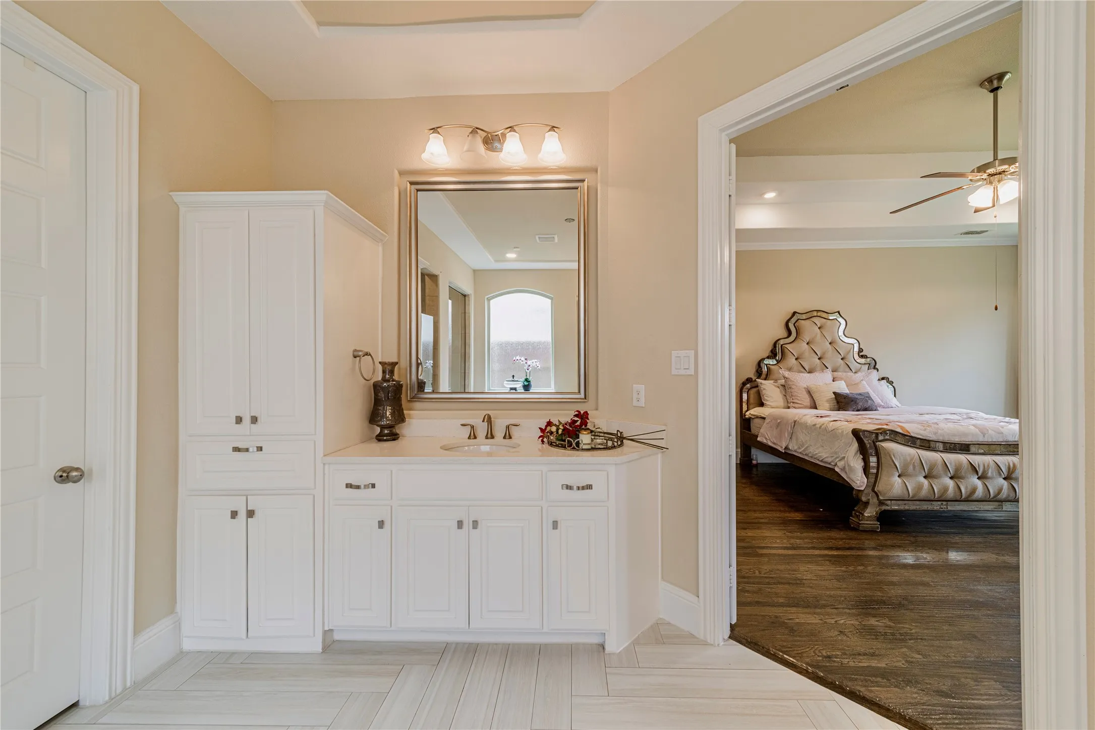 Vanity with white cabinetry, integrated sink, and wall-mounted mirror