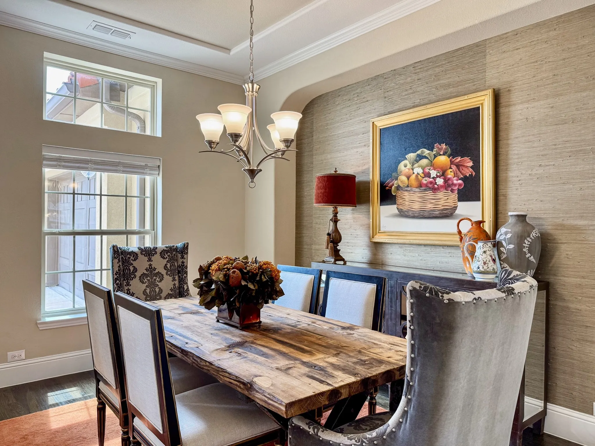 Tray ceiling with crown molding, chandelier lighting fixture, grasscloth wall covering, dark wood-finish flooring, and multi-pane windows