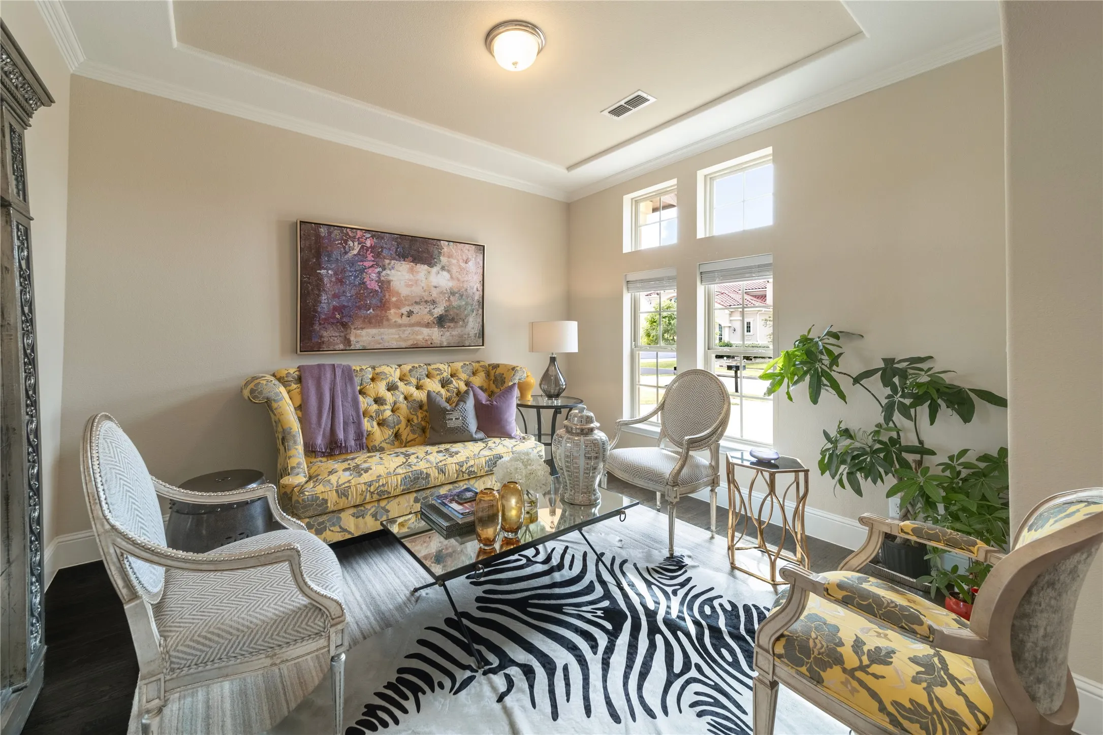 Tray ceiling with crown molding, light-toned walls, wood-finish flooring, multiple windows with blinds, and a built-in recessed light fixture