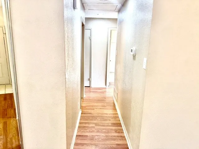 Wood-finish flooring throughout the hallway
