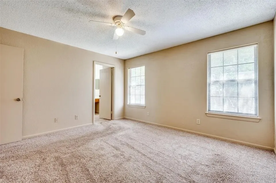 Neutral-toned walls complement the textured carpeting