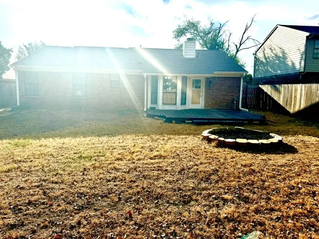 Brick exterior featuring a wood deck and a built-in fire pit