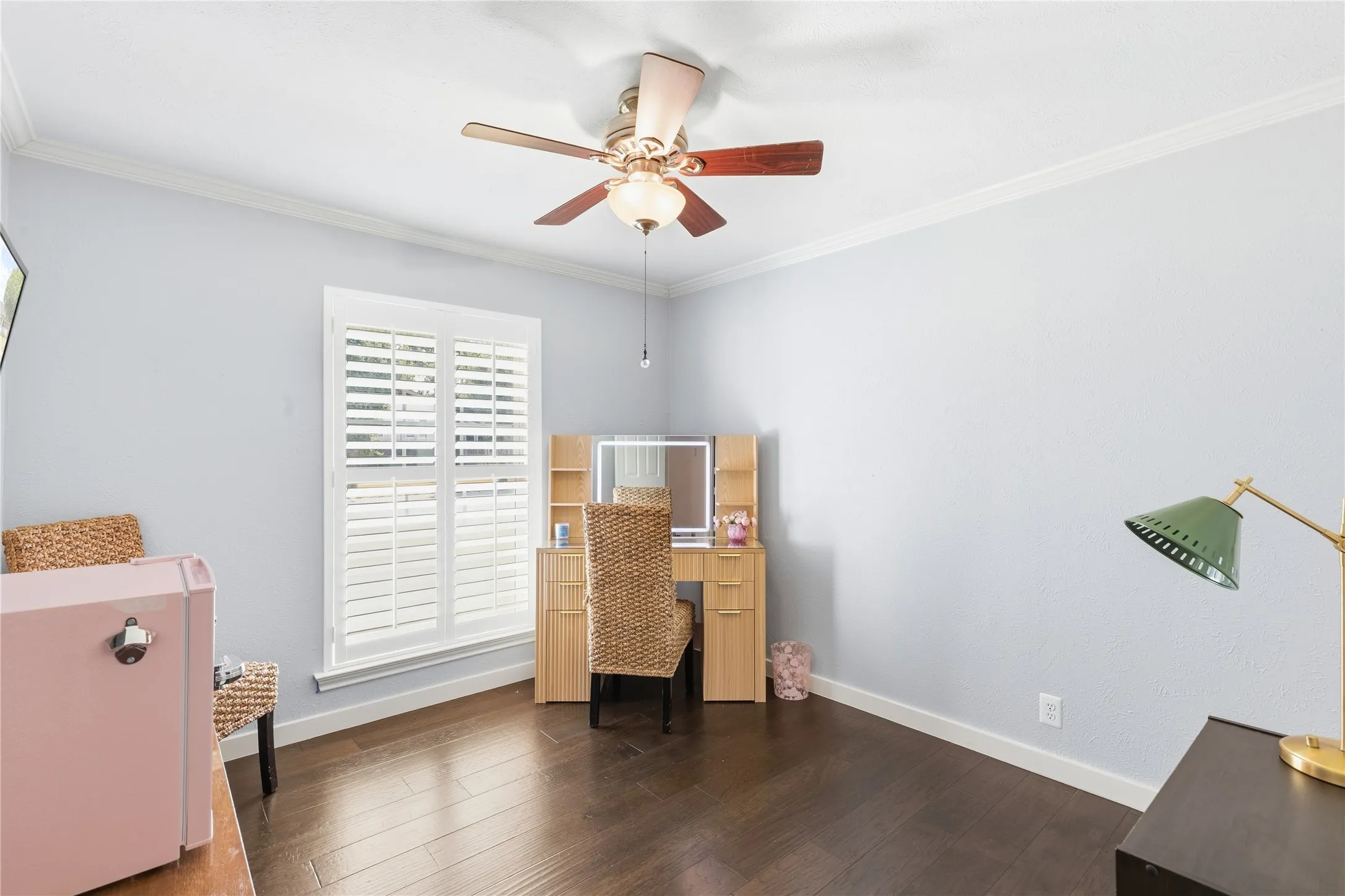 Crown molding accentuates the ceiling, complemented by a ceiling fan with integrated lighting