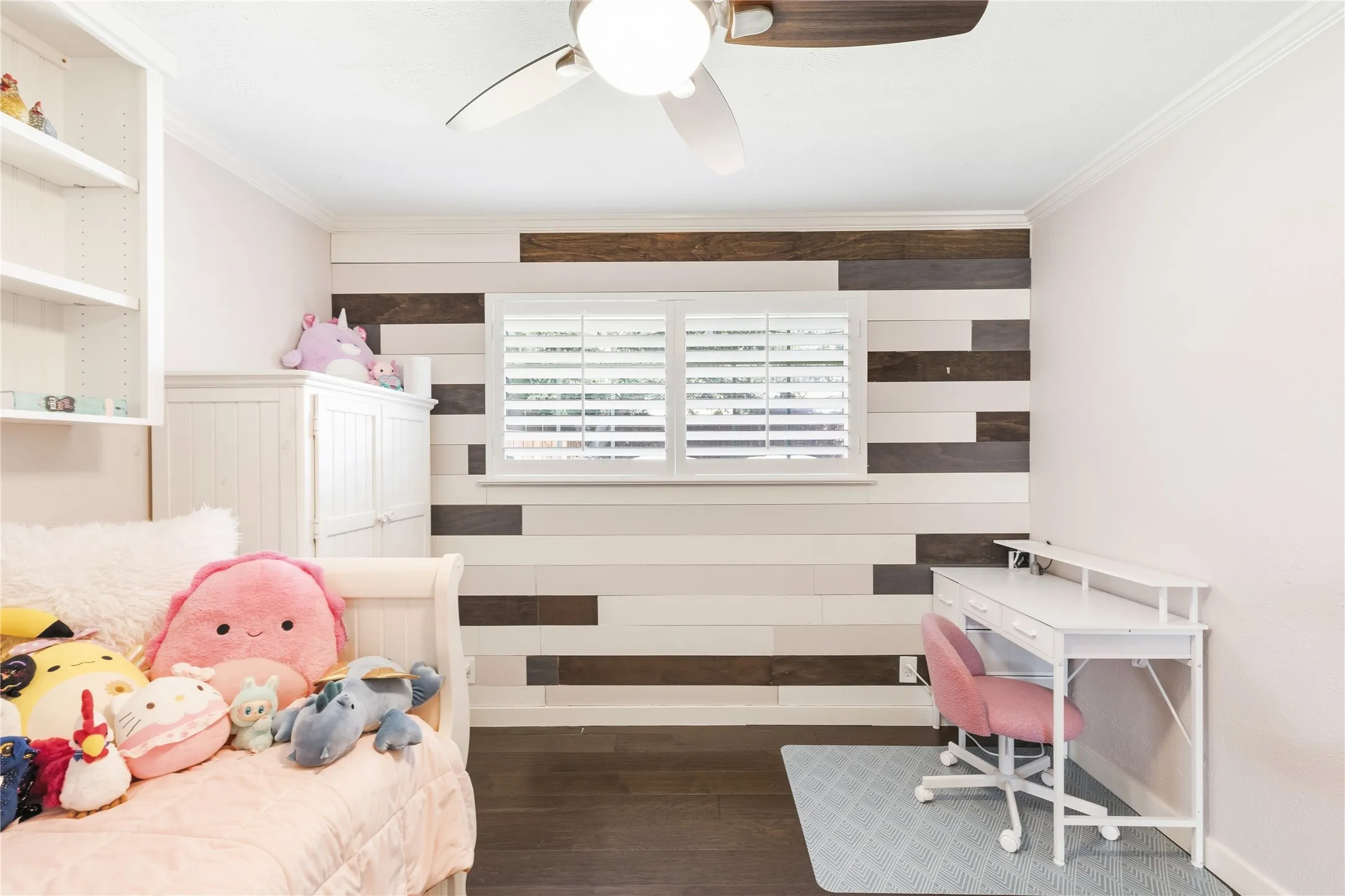 Wood-finish flooring with a decorative accent wall and built-in shelving