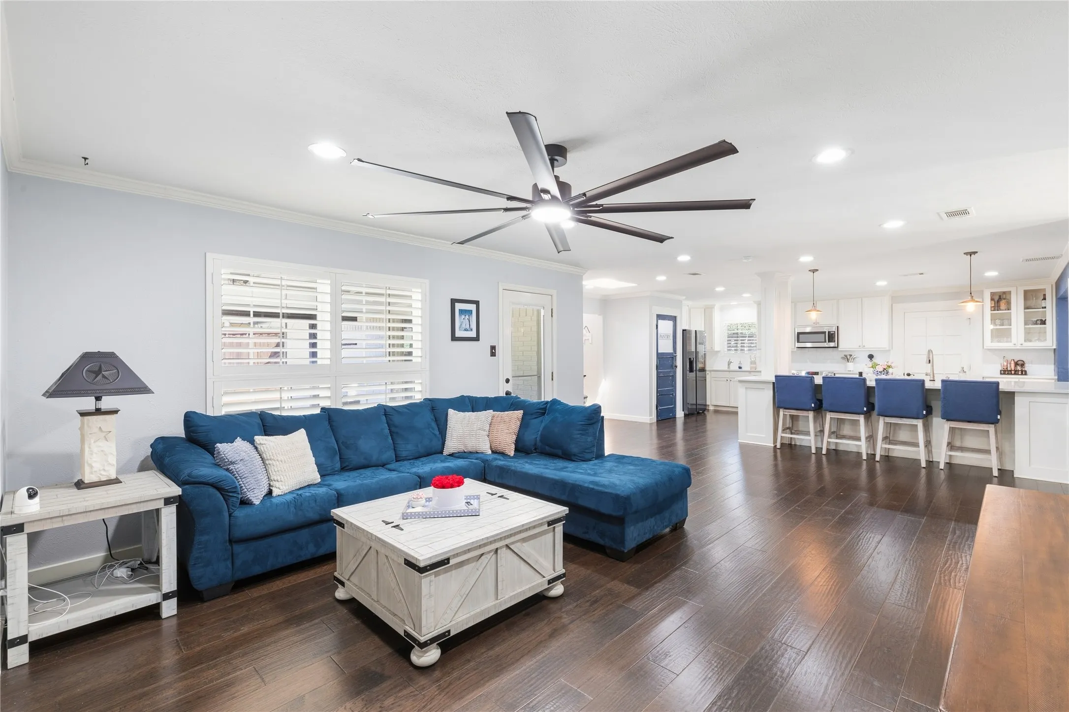 Open-concept living space featuring wood-finish flooring, recessed lighting, and a large ceiling fan