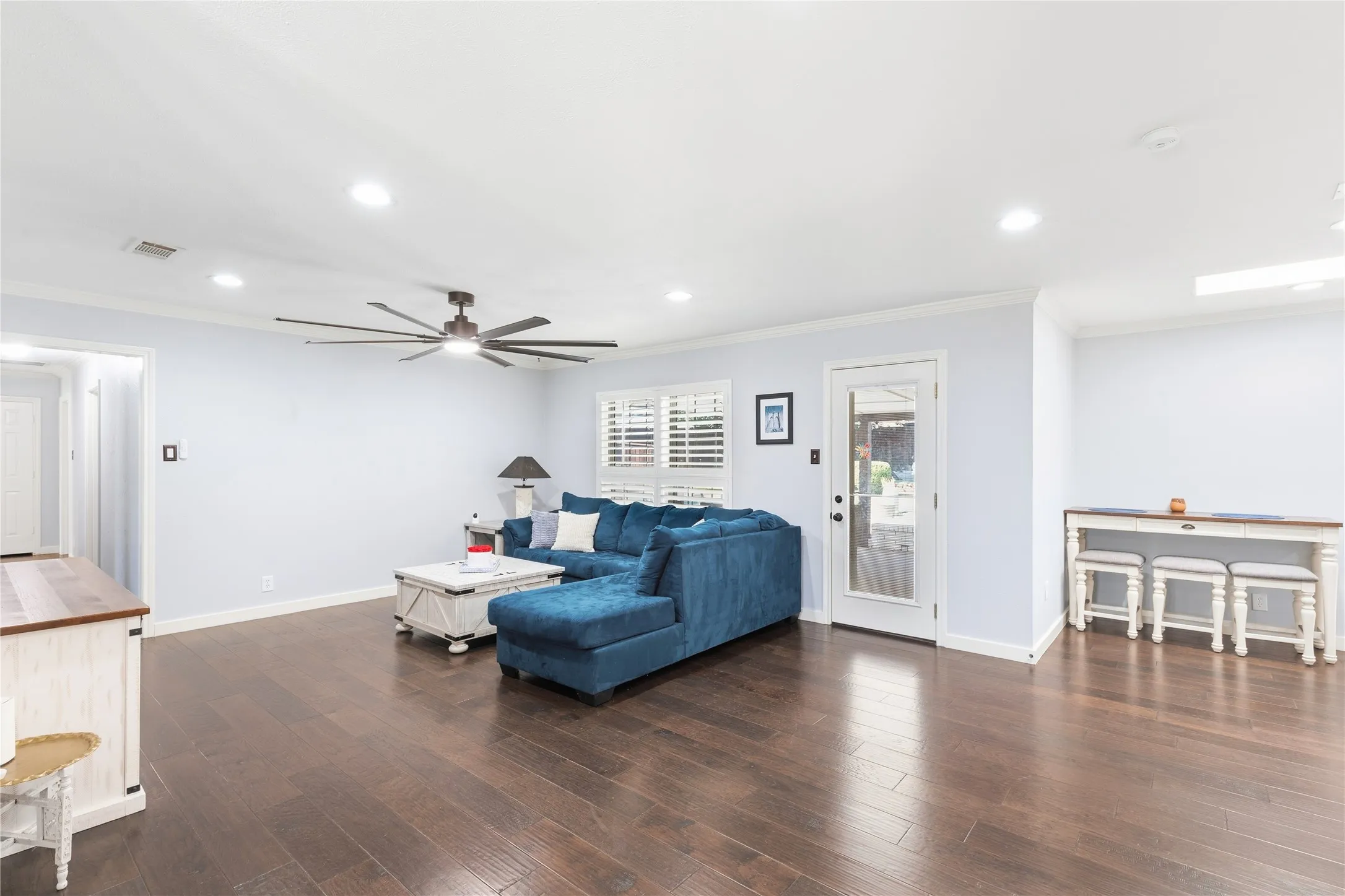 Hardwood flooring, recessed lighting, ceiling fan, white plantation shutters, and a glass-paneled door