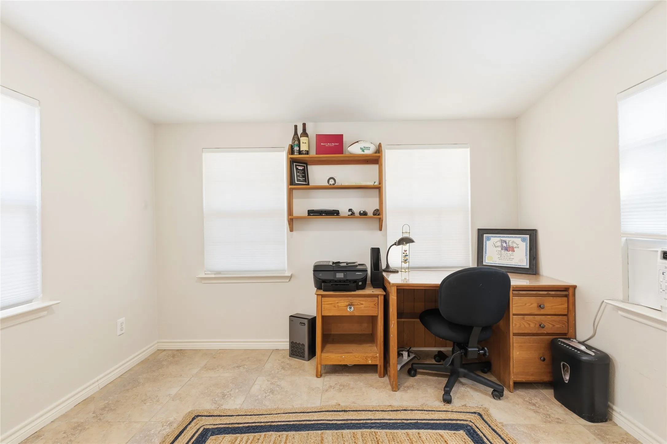 Neutral wall color with multiple windows and white window coverings