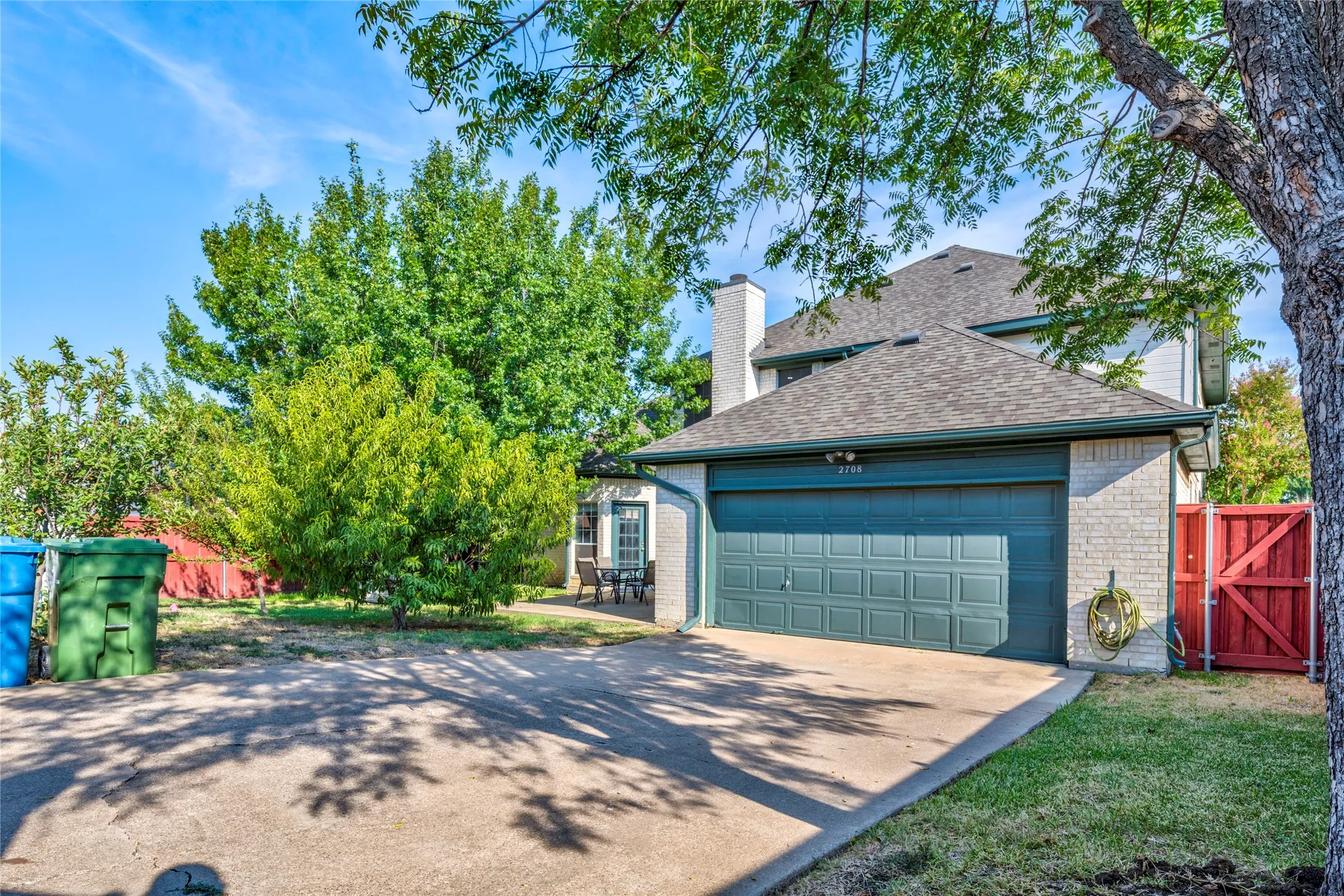 Brick exterior with an attached garage, featuring a shingled roof and a red wooden fence. This area is gated so completely private....