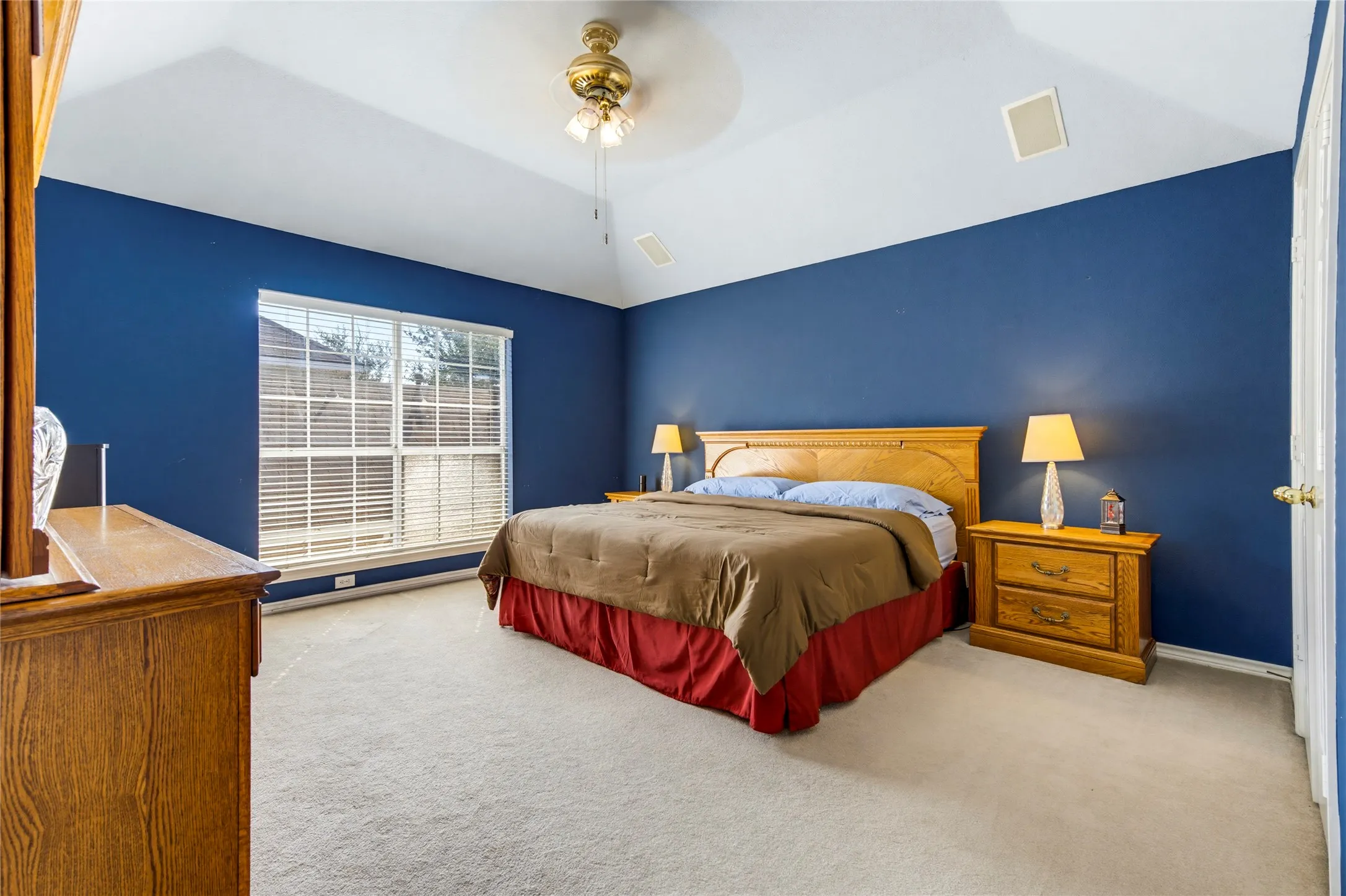 Vaulted ceiling with a ceiling fan, carpeted flooring, and a large window with blinds. This is the 4th bedroom AND it is wired for surround sound so can be con