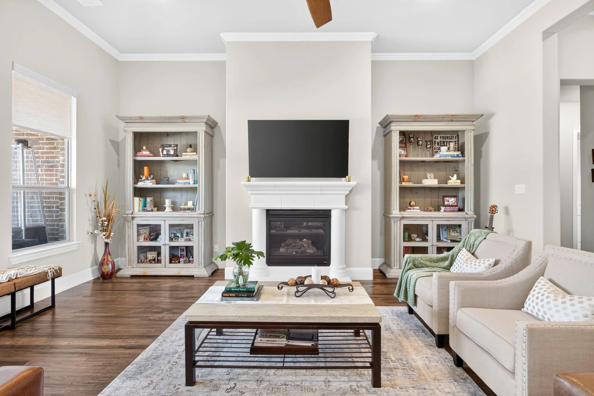 Hardwood-finish flooring, built-in fireplace with hearth, crown molding, a ceiling fan, and recessed lighting