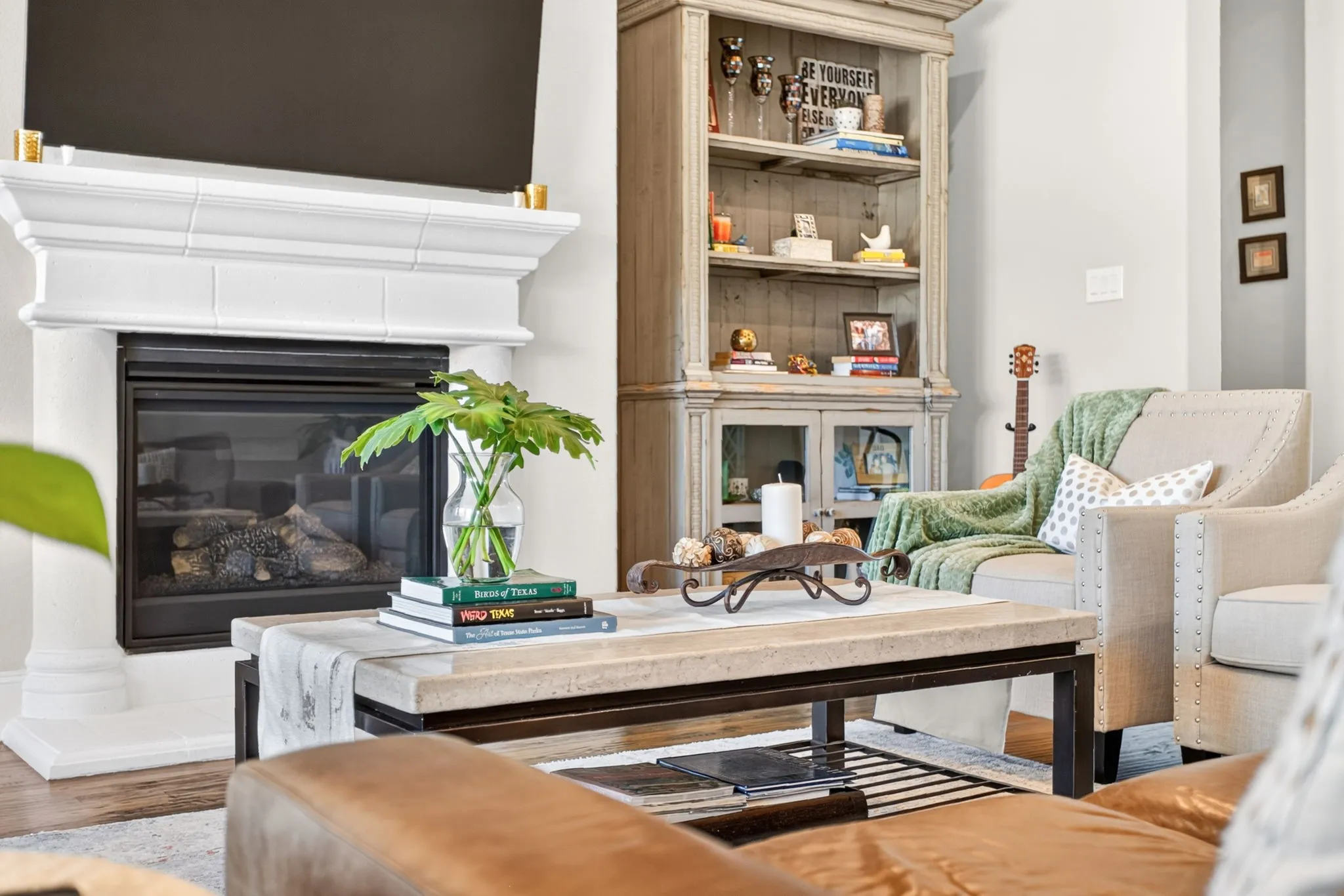 Fireplace with a classic white mantel, wood-finish flooring, and built-in shelving