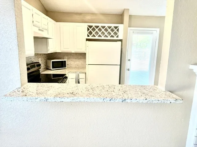 Kitchen pass-through with a light-toned speckled countertop