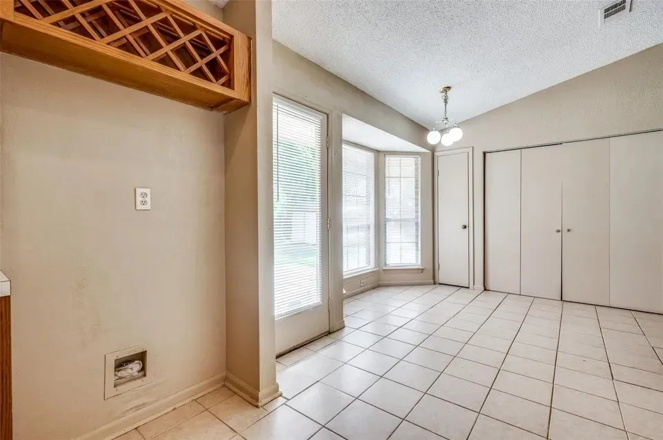 Ceramic tile flooring, built-in wooden wine rack, bay window, sliding closet doors, and sloped ceiling