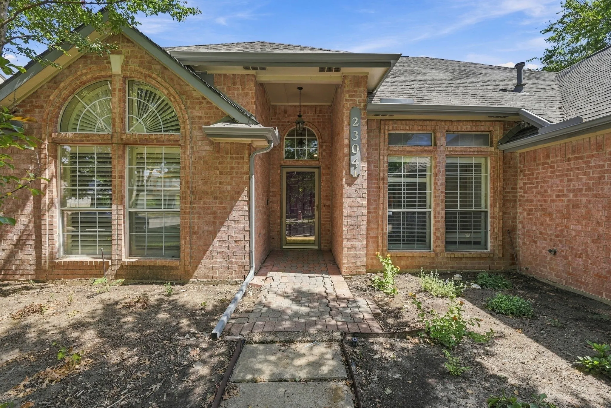 Brick facade with arched window accents, transom window details, and an inviting covered entry