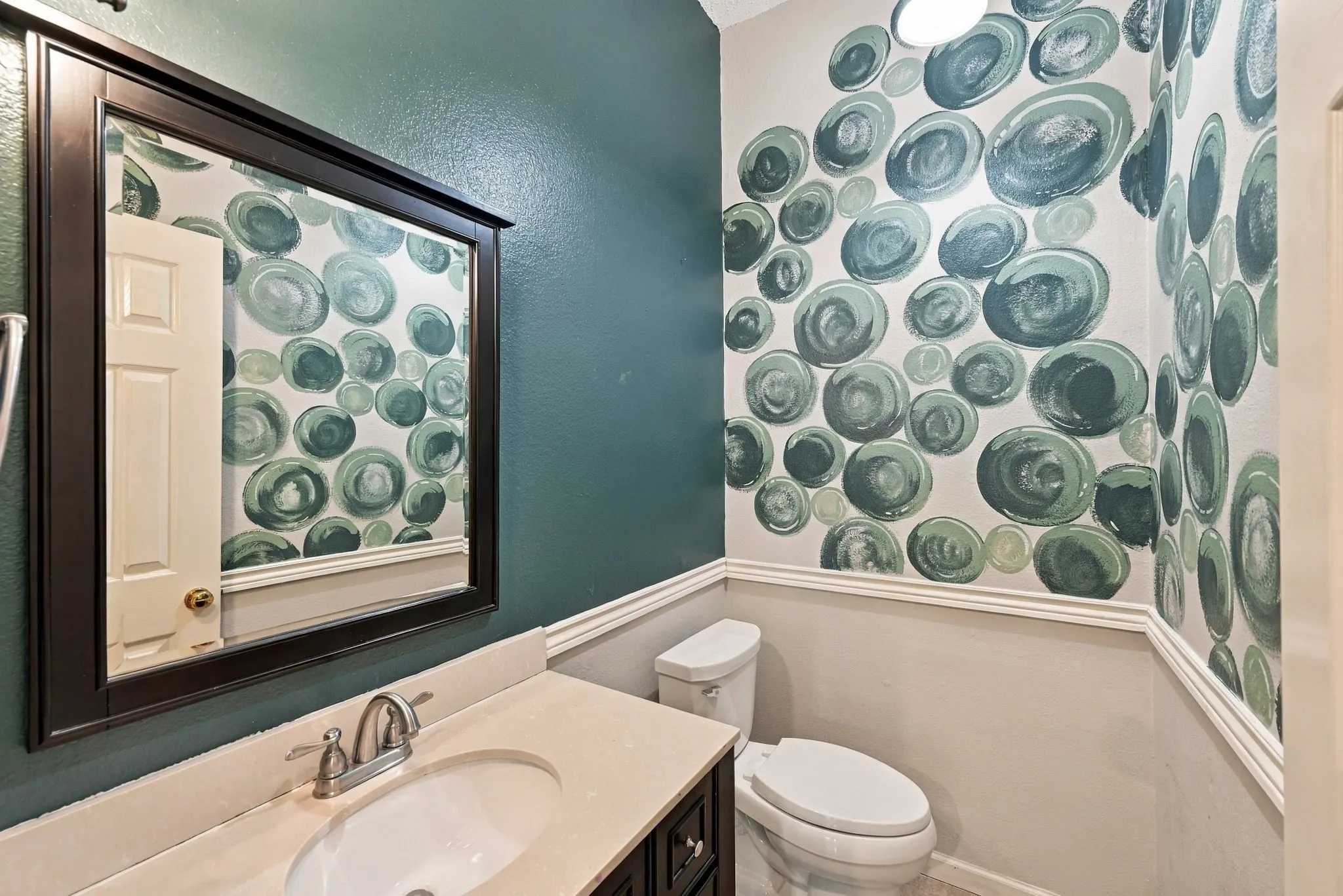 Vanity with an integrated sink, brushed nickel faucet, and neutral countertop
