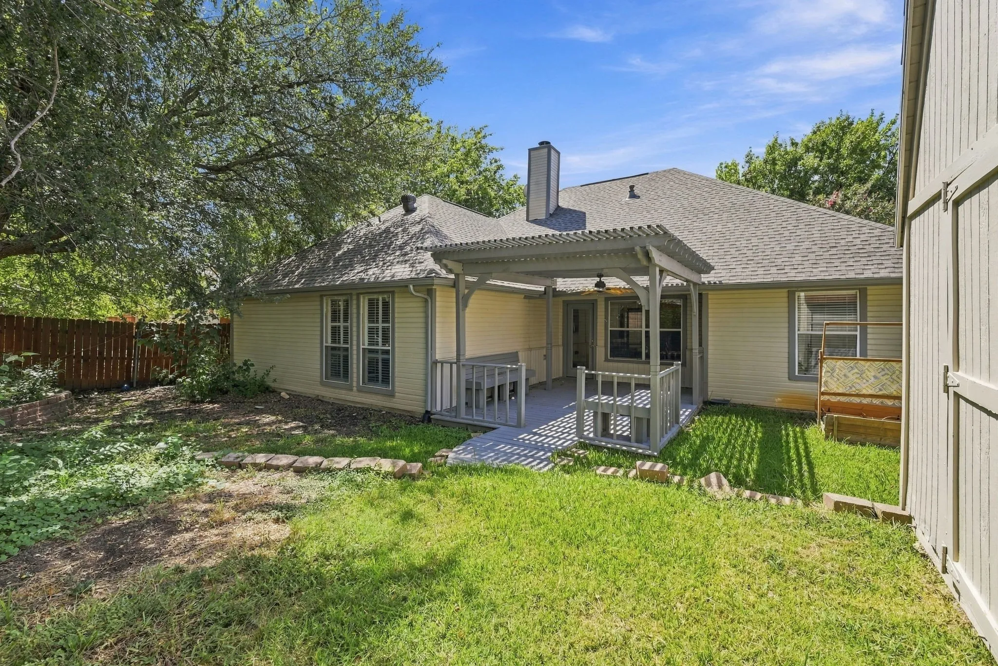 Rear exterior featuring a covered patio, pergola, and fenced yard