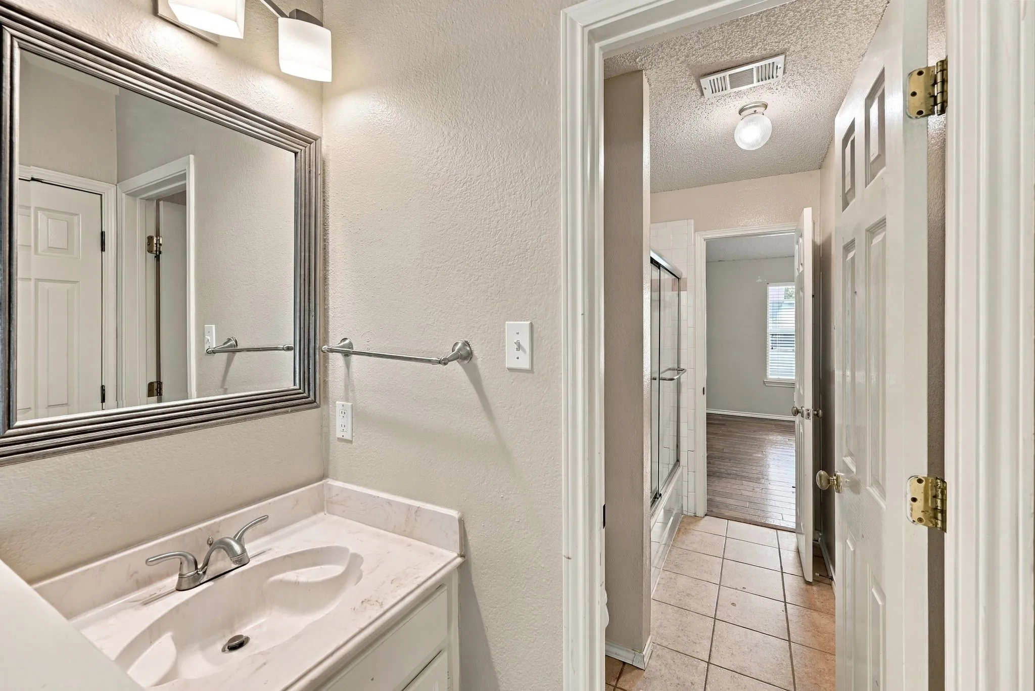 Vanity with integrated sink, chrome faucet, and framed mirror