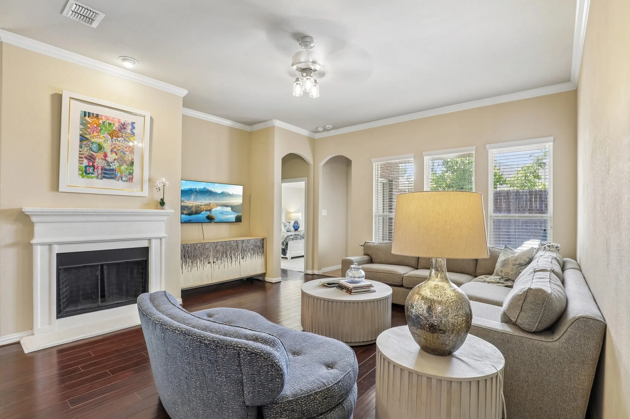 Living room features cozy fireplace and wall of windows for natural light.