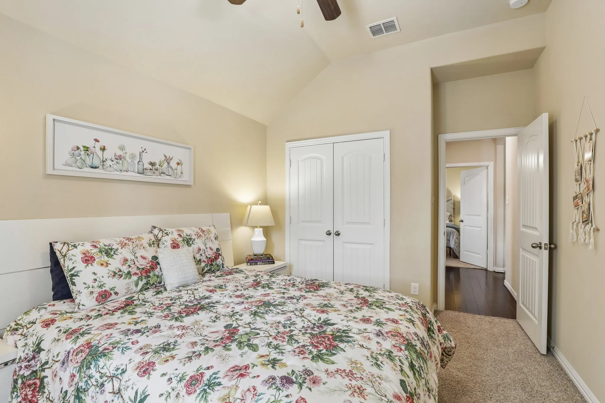 Secondary bedroom with vaulted ceiling and double-door closet.
