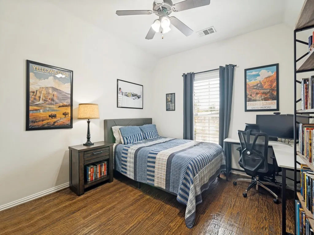 Upstairs secondary bedroom with wood floor and walk-in closet.
