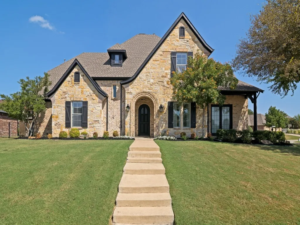 Gorgeous curb appeal to this custom home with stone and brick exterior!