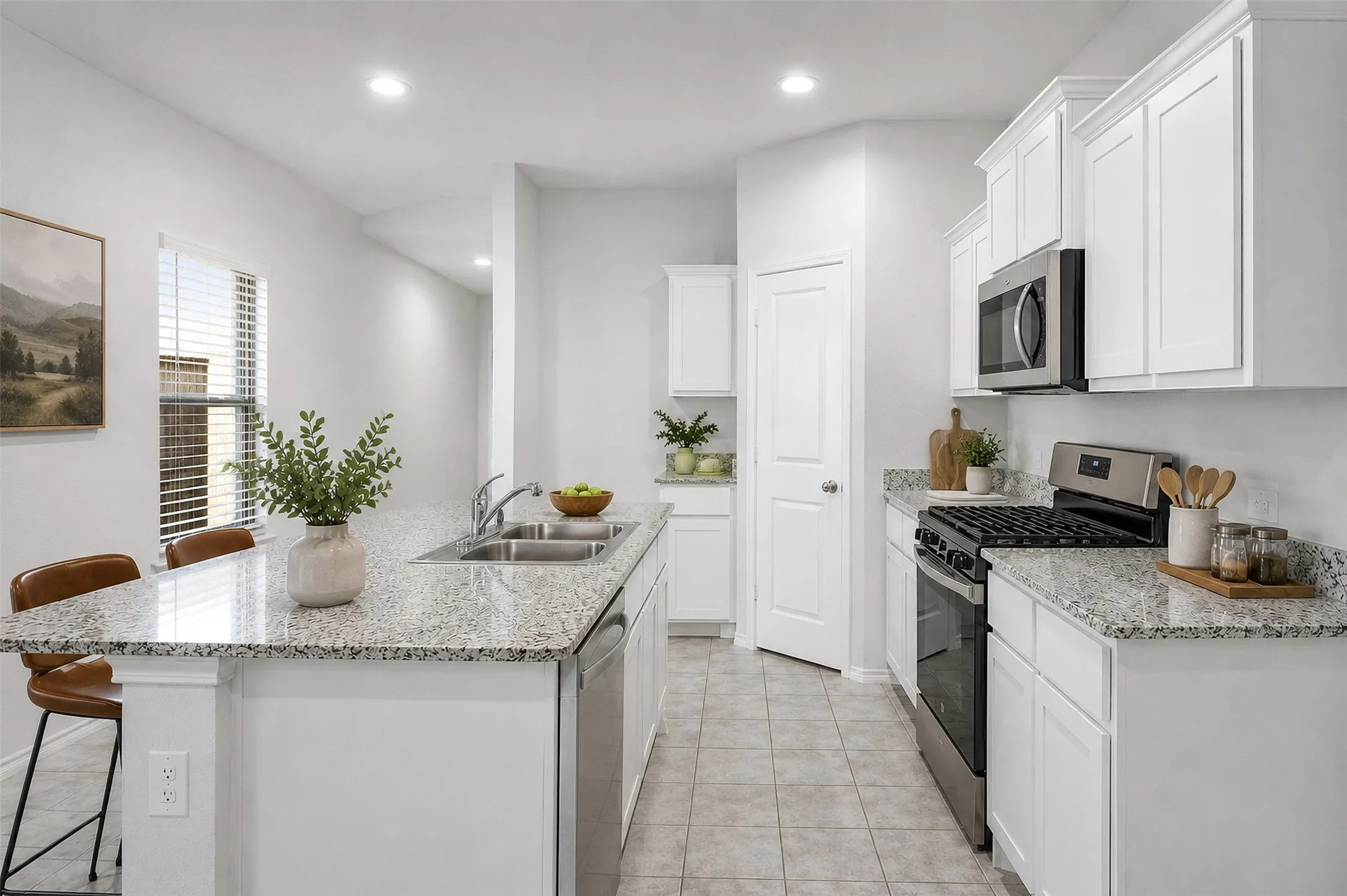 Kitchen featuring a double basin sink, stainless steel appliances, white cabinetry, and light-toned countertops