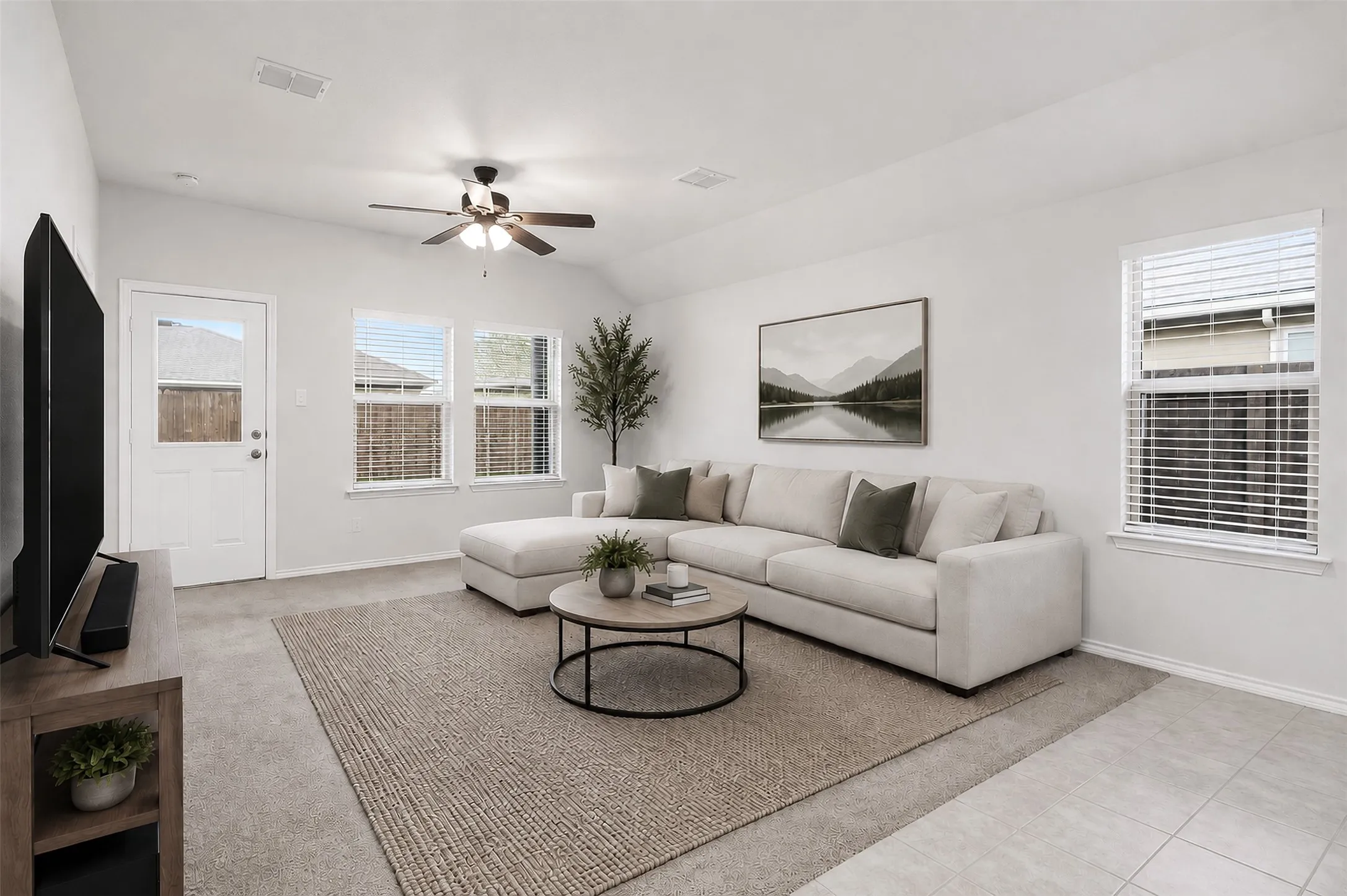 Vaulted ceiling with a ceiling fan, multiple windows, white painted walls, carpeting, and tiled flooring