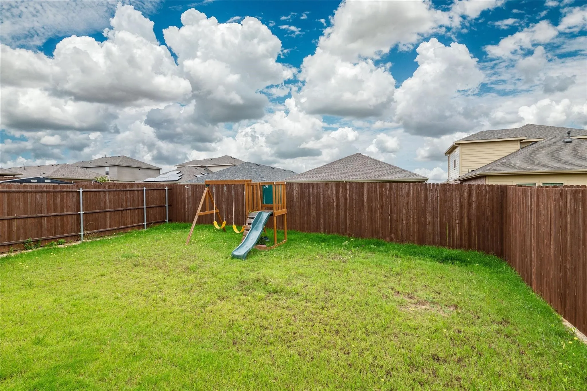 Expansive fenced backyard with a grassy lawn