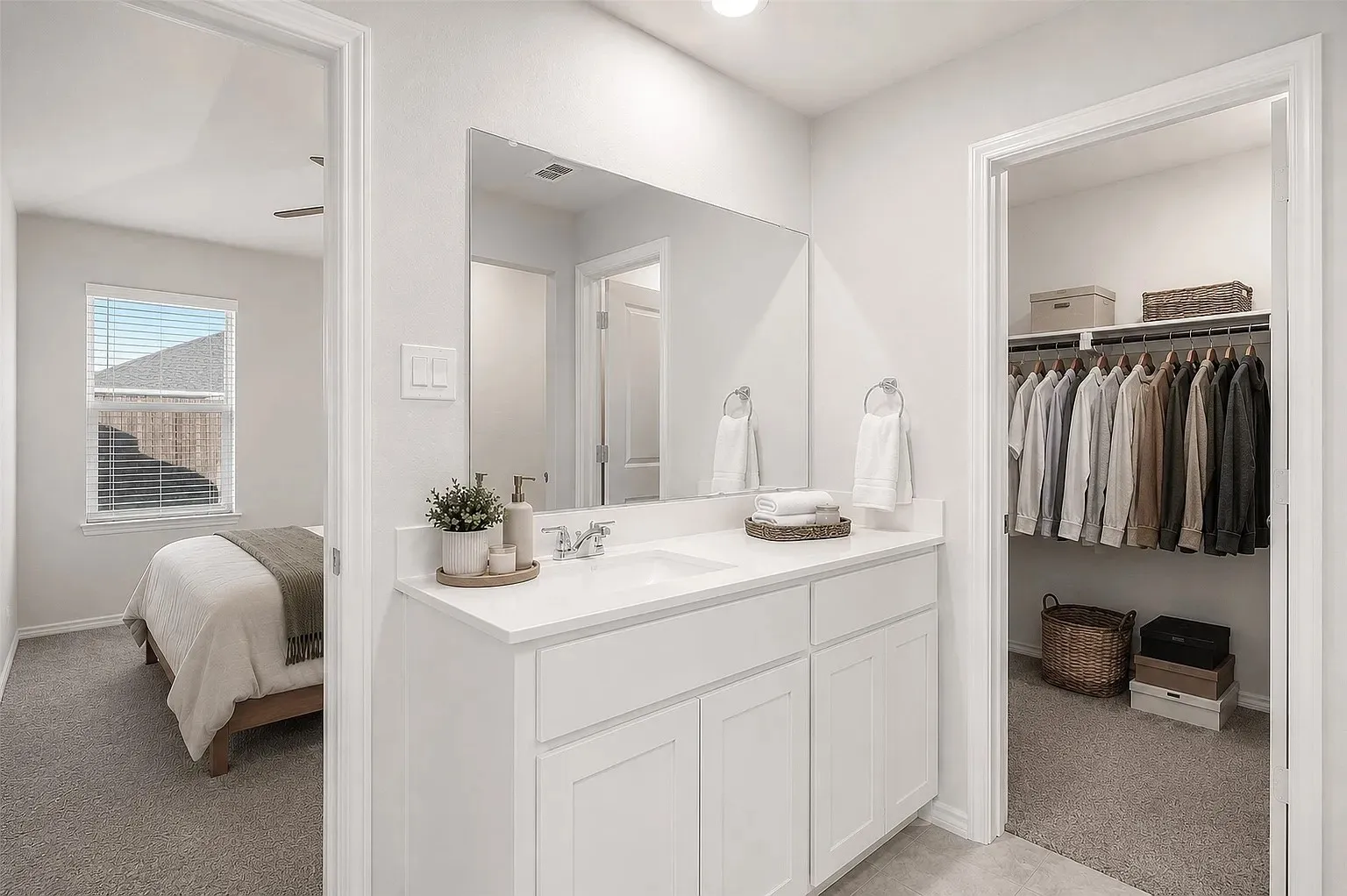 White vanity with a single sink, chrome faucet, and quartz countertop