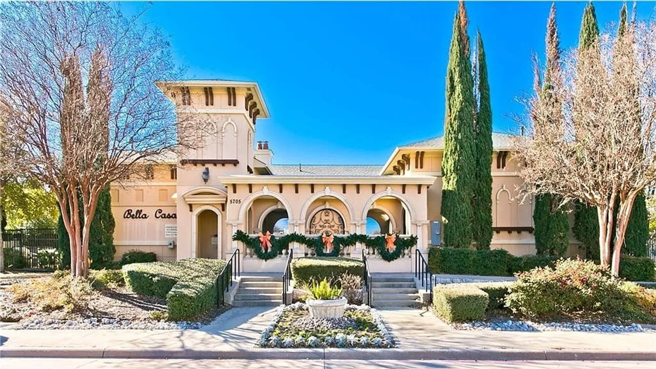 Mediterranean-inspired architecture with arched entries, a prominent tower, and a paved entryway