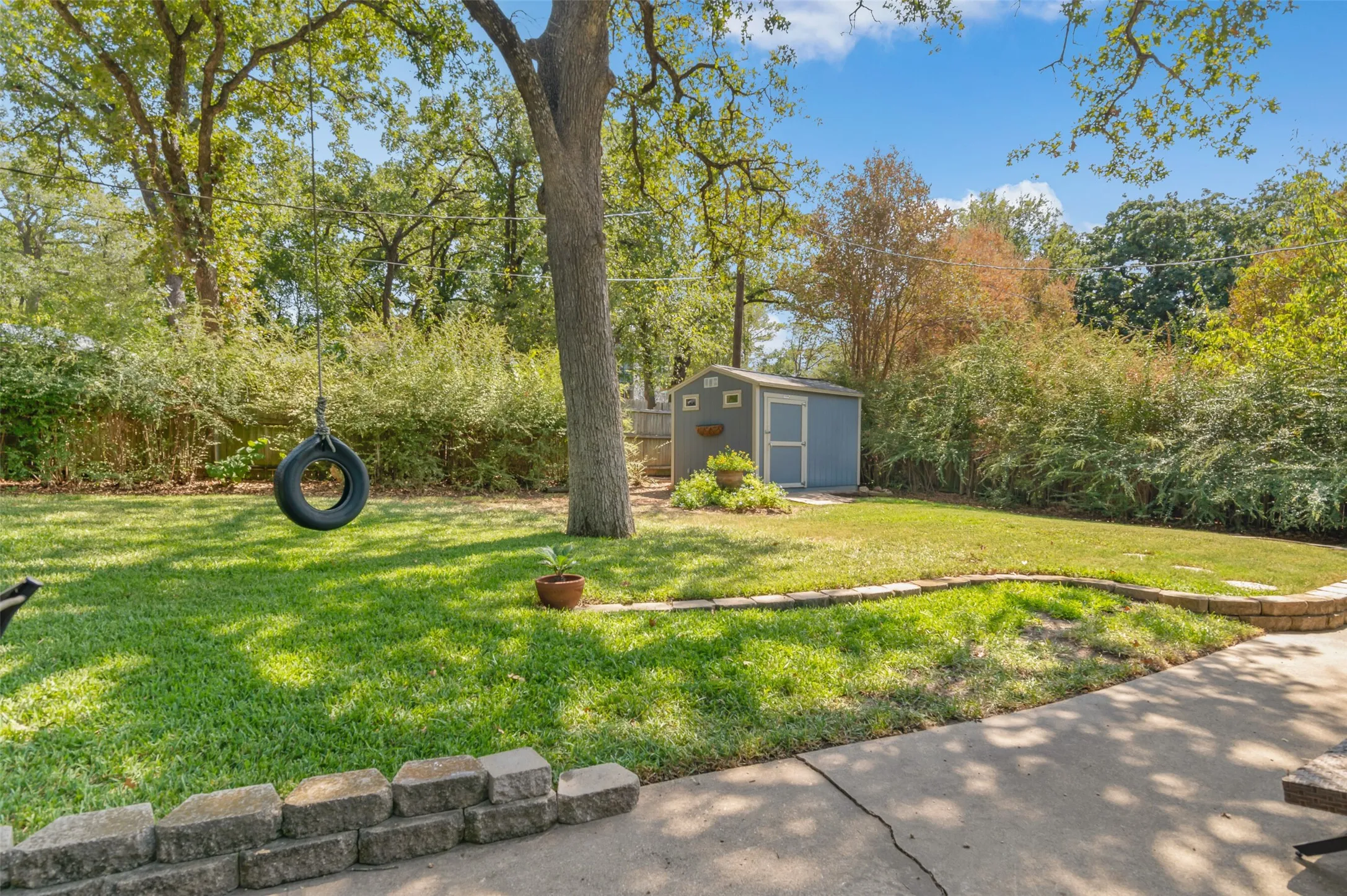 Summers are a breeze under the shade of the trees this back yard has to offer!