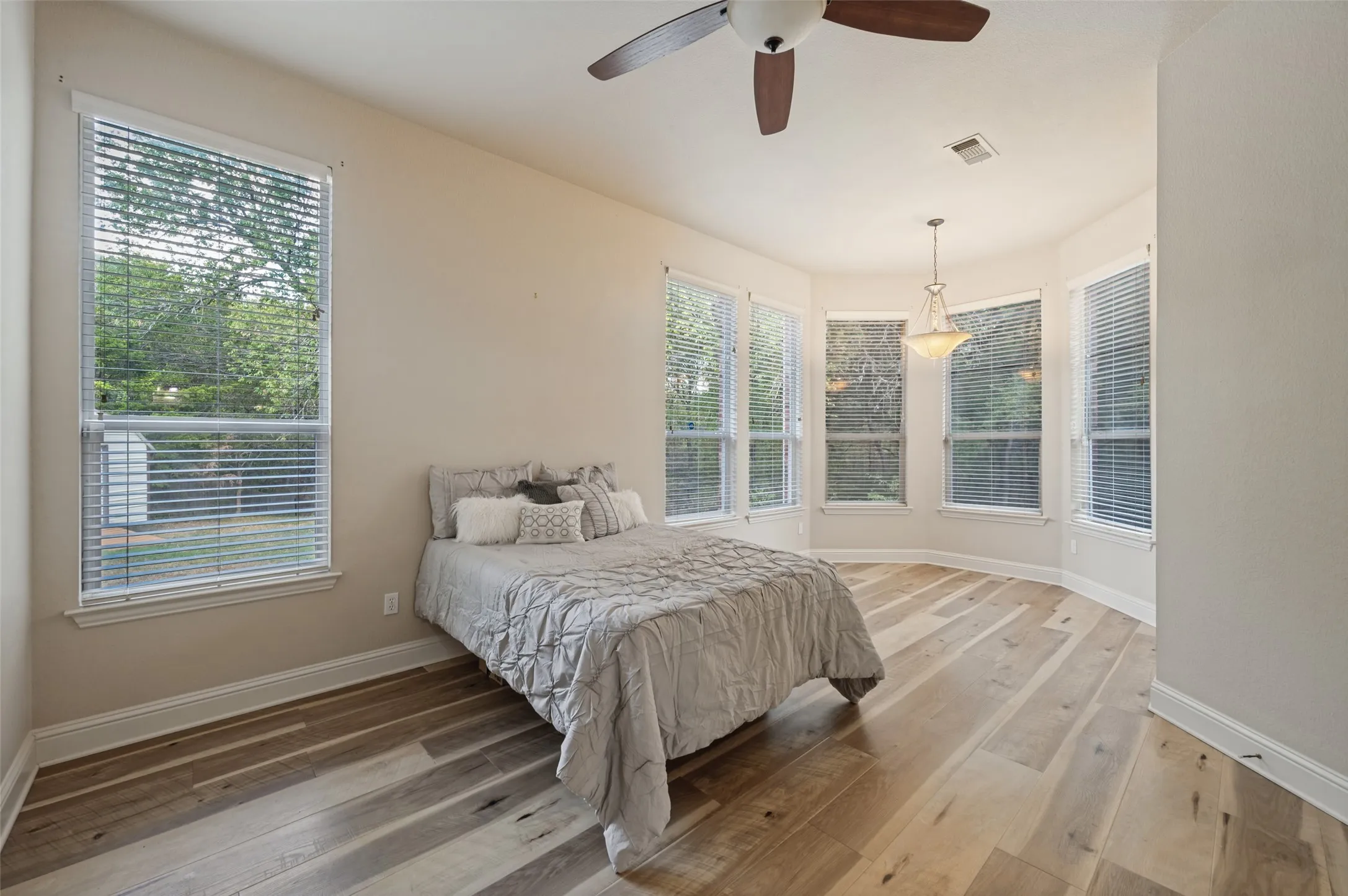 This oversized primary bedroom also features a ceiling fan, an abundance of natural light and a fabulous seating area that over looks the yard and pool