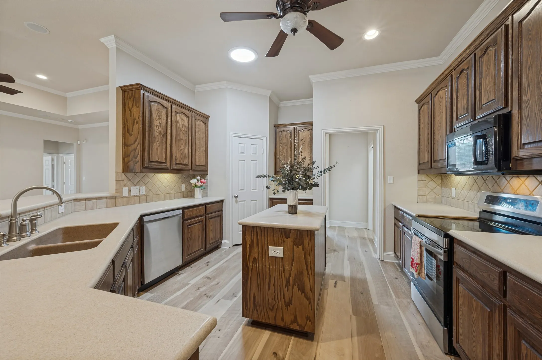 Large kitchen features an abundance of counter space, island, uner mount lighting, walk in pantry, stainless steel appliances and induction stove