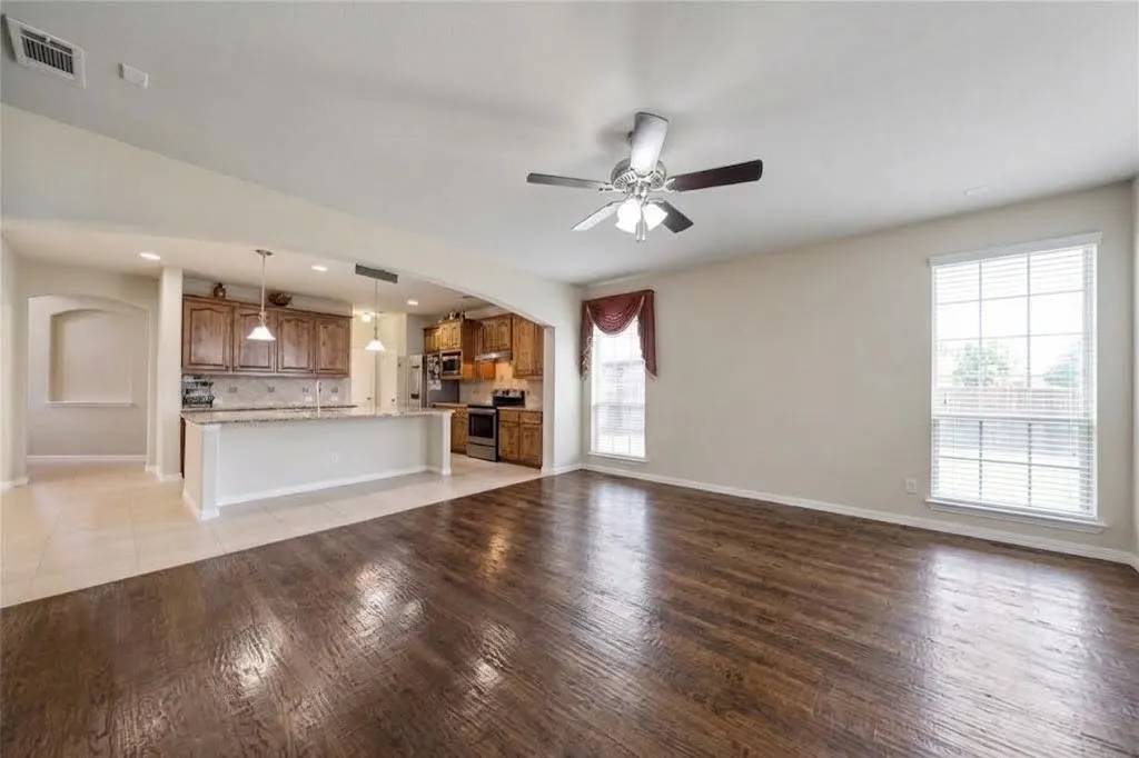 Dark wood-finish flooring, recessed lighting, and a ceiling fan
