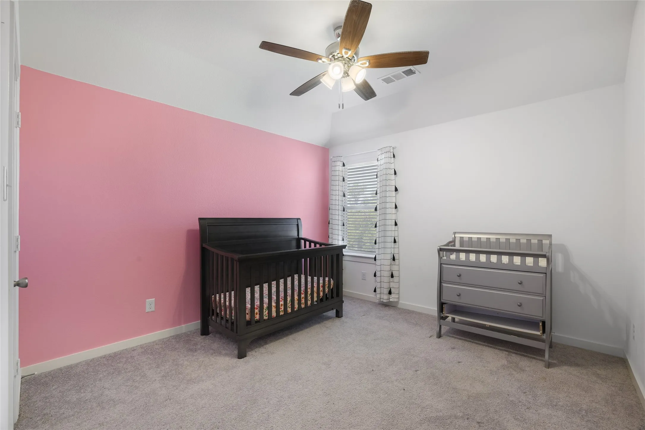 Recessed window with blinds, ceiling fan with light fixture, and wall-to-wall carpeting